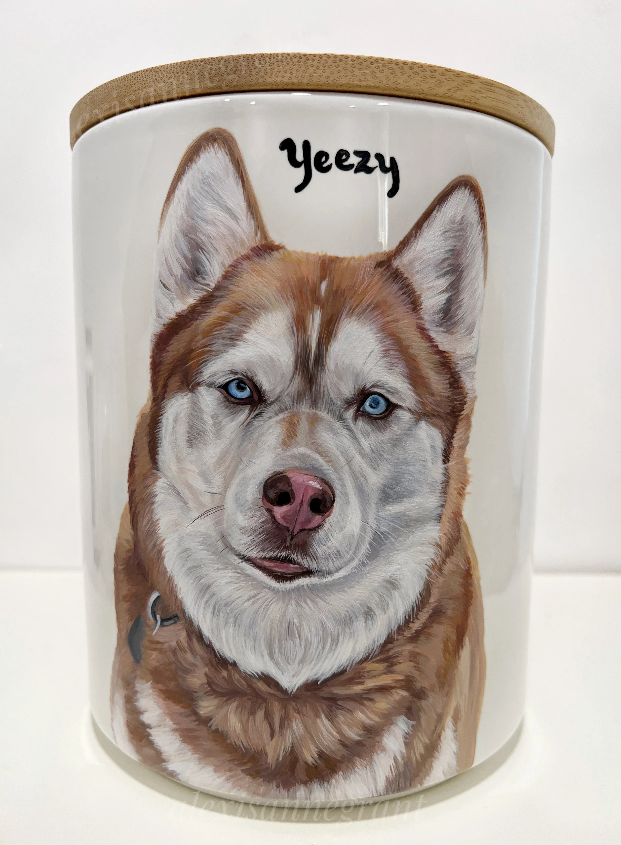 hand painted dog portrait urn husky portrait this light brown husky has blue eyes, his name is hand painted above his portrait on a white ceramic pet urn with wood lid