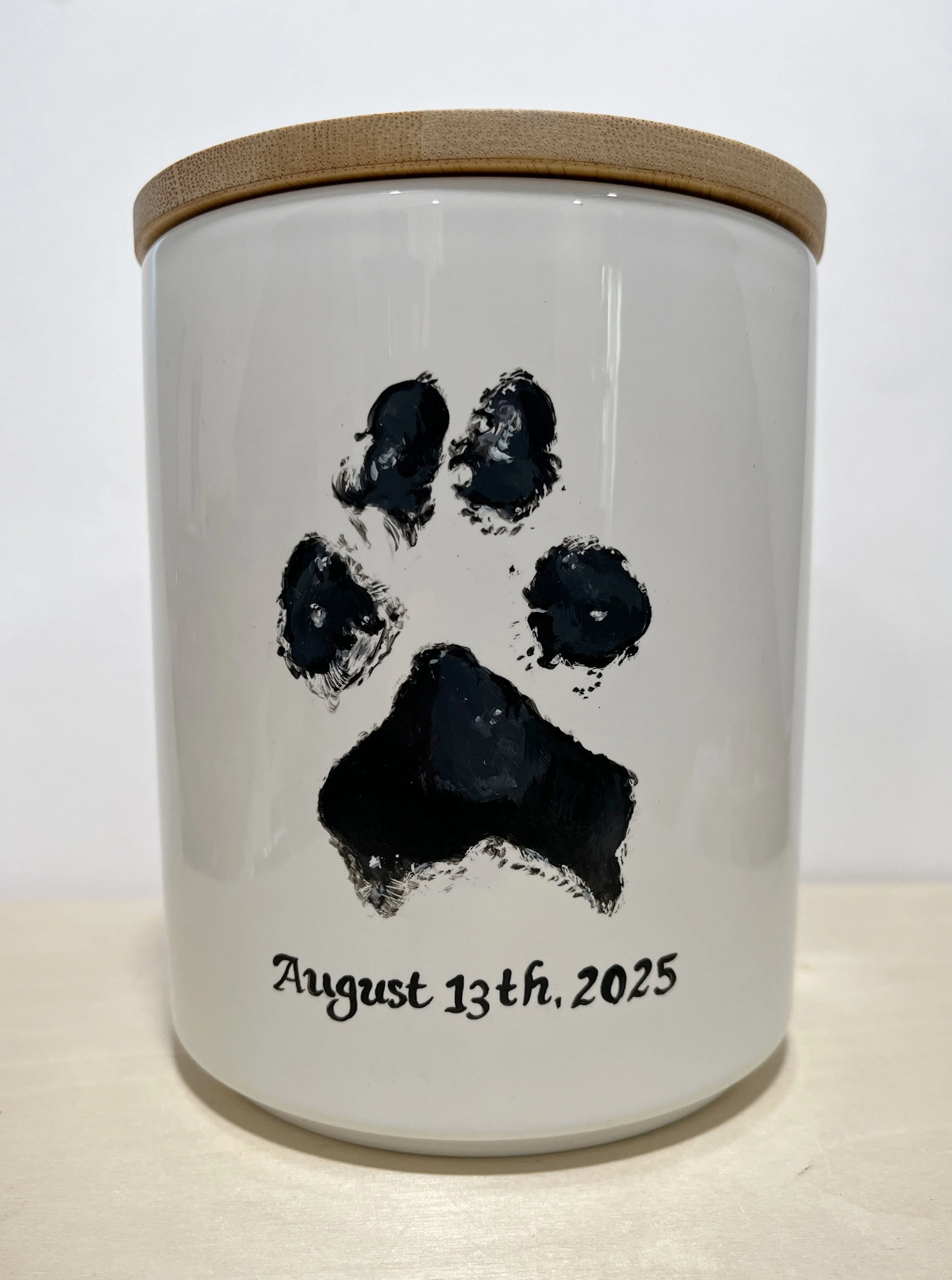 dog portrait urn with paw print and dates hand painted on the back of the ceramic urn