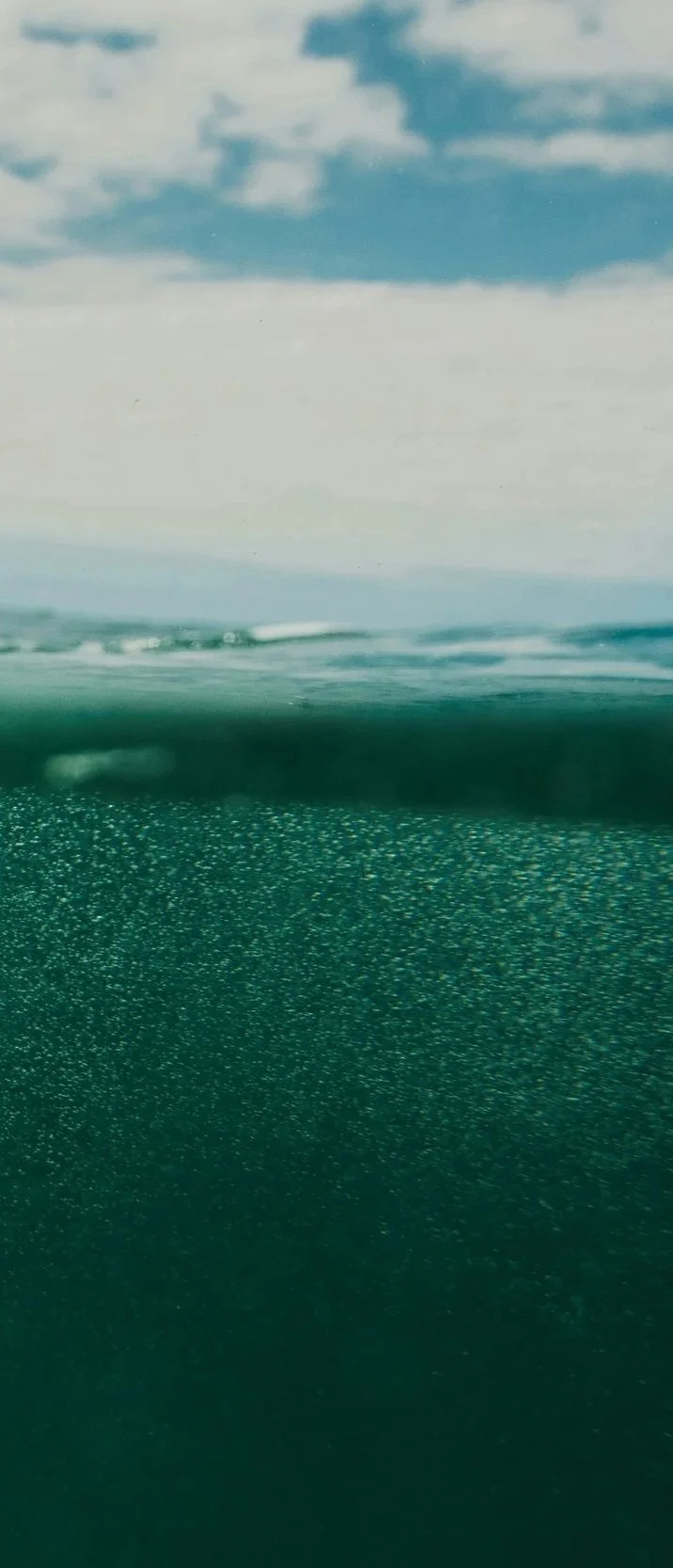 A view of the ocean with waves and a partly cloudy sky.