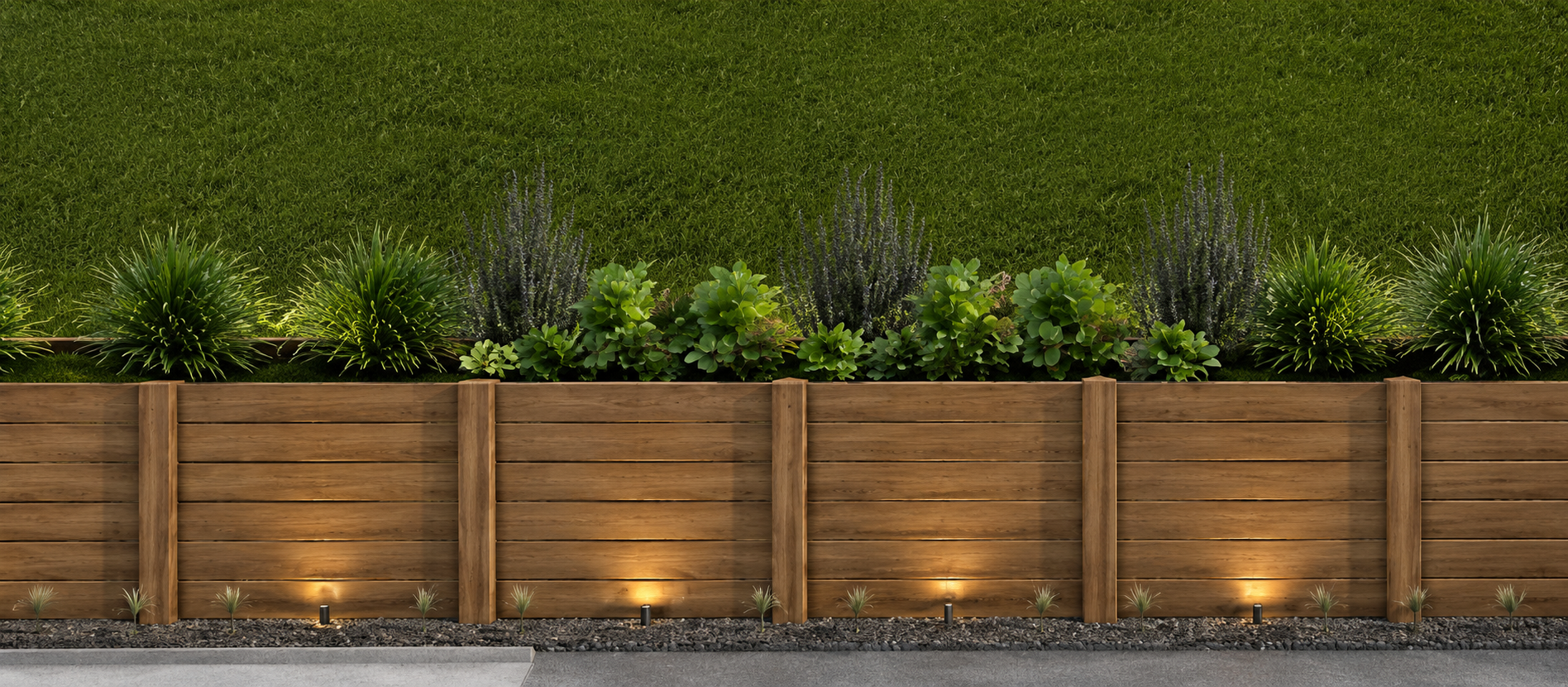 Wooden fence with built-in lighting, small plants, and lush green bushes behind, with a grassy area in the background.