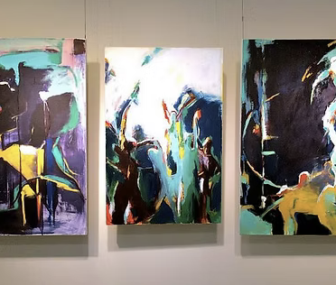 Three abstract paintings with vibrant colors and dynamic brushstrokes hanging on a gallery wall.