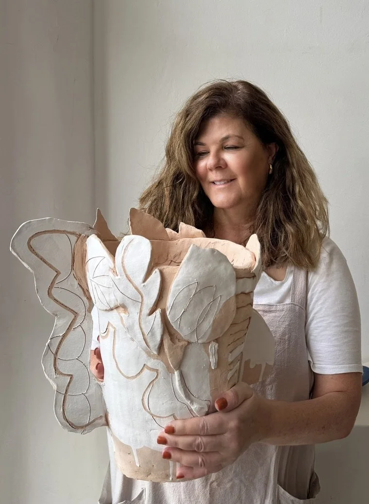 Woman holding a large, detailed paper mache butterfly sculpture.