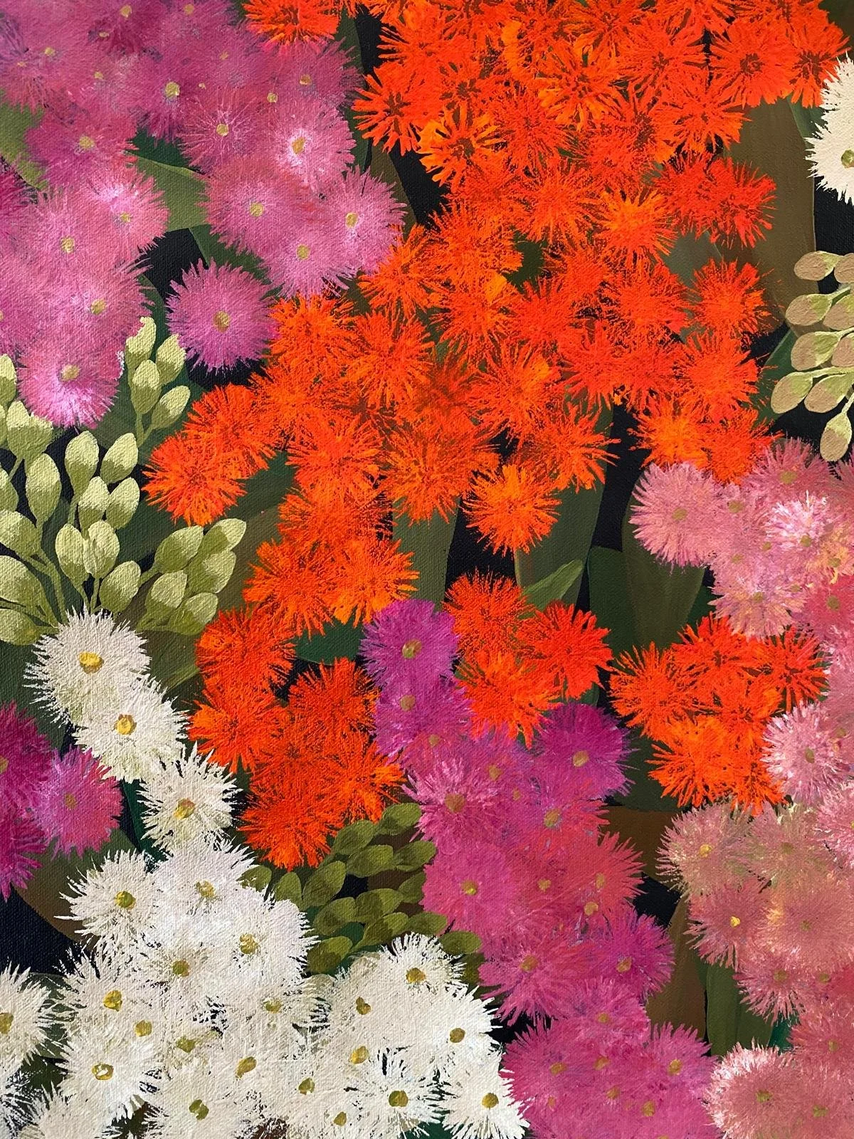 A bunch of colorful fluffy flowers in shades of pink, white, orange, and purple with green leaves.