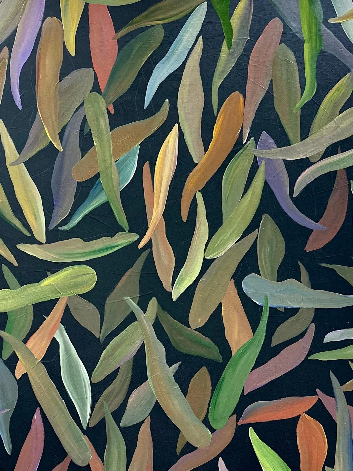 Close-up of multicolored leaves on a dark background, creating a vibrant and abstract pattern.