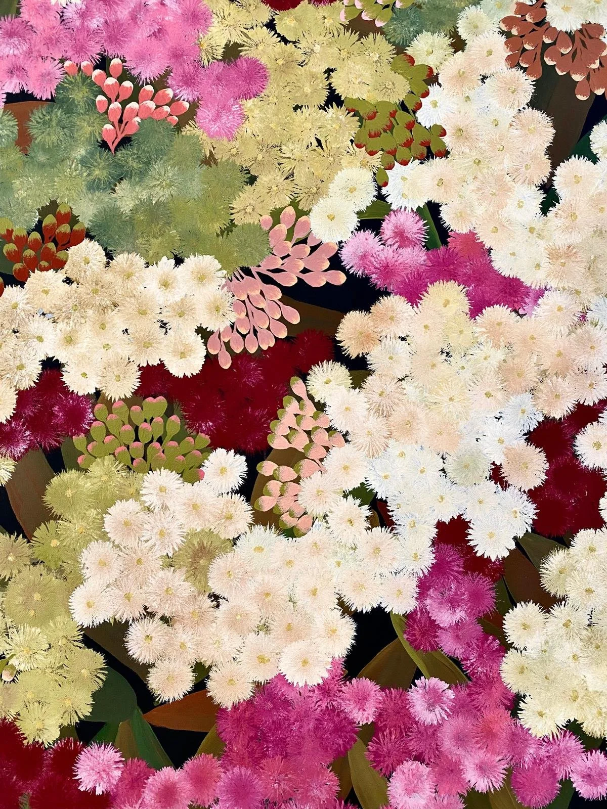 Arrangement of various colorful flowers including pink, white, red, and green blossoms in a garden setting.