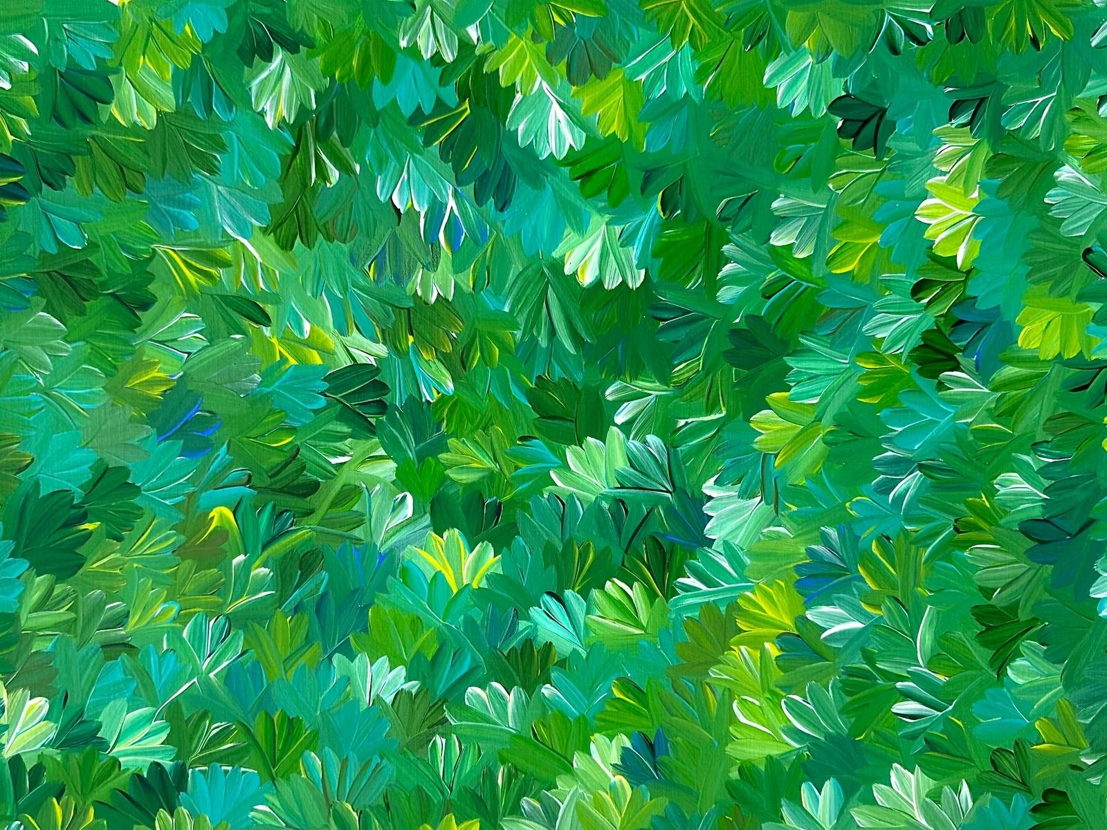 Close-up view of green leaves from various plants, overlapping each other.