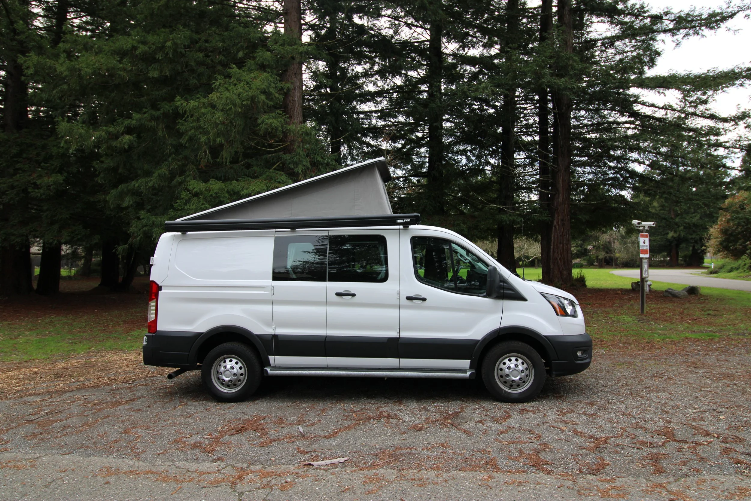 A white Ford Transit with pop-top roof