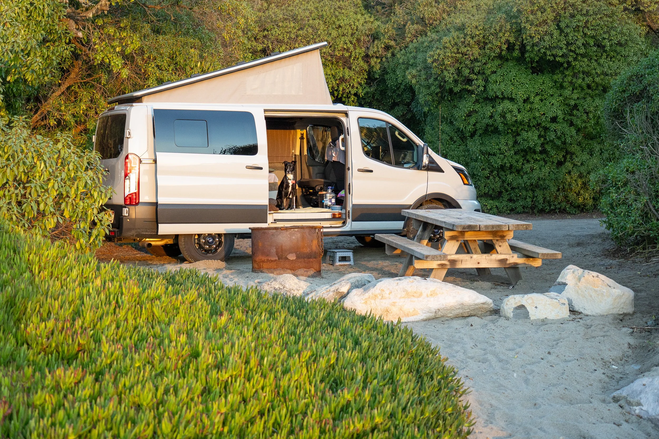 Ford transit van at the beach with pop-top and doors open