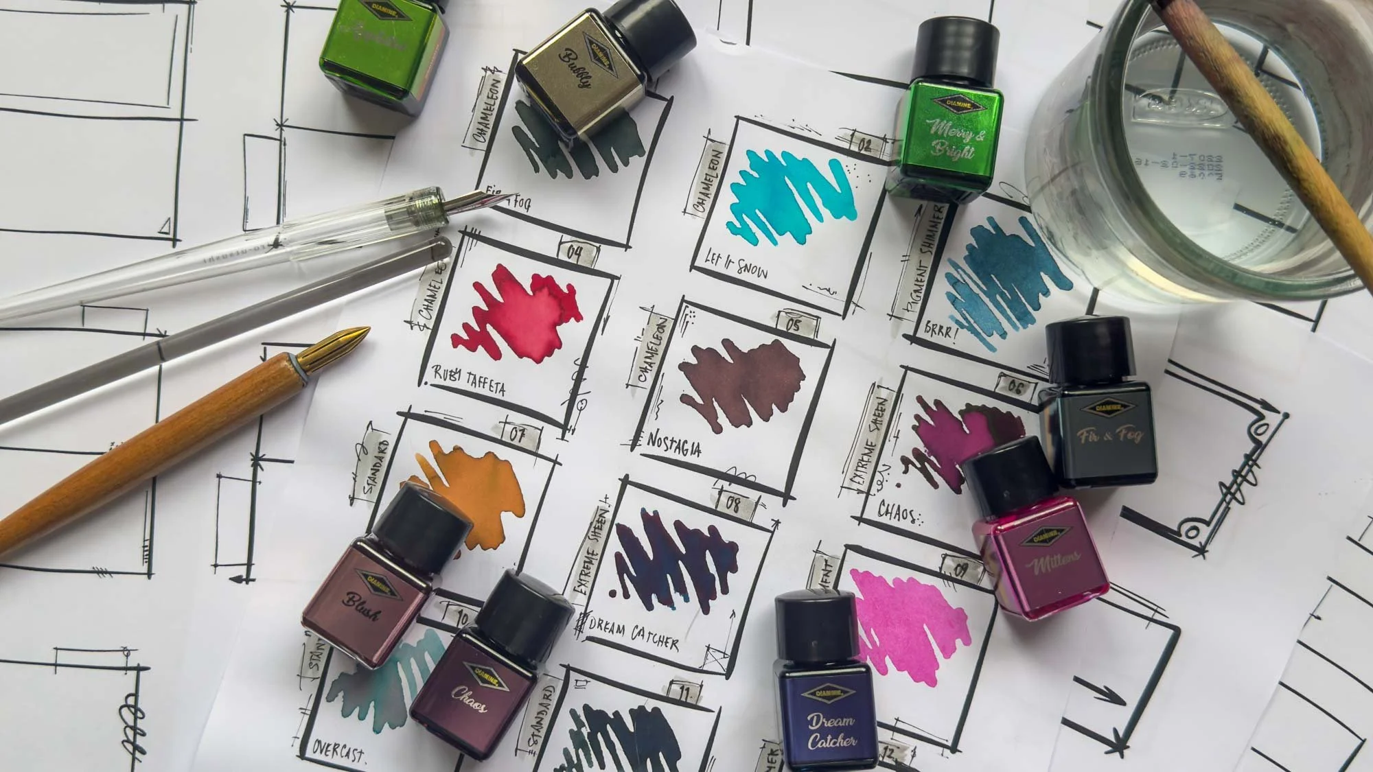 Printed Desktop Nerd ink swatch sheets with colourful ink samples, ink bottles, dip pen, brush, and water glass.