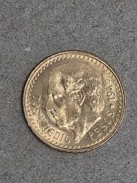 Moneda de oro con la imagen de un hombre de perfil y texto en inglés.
