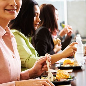 People eating breakfast at a table with plates of food and drinks.
