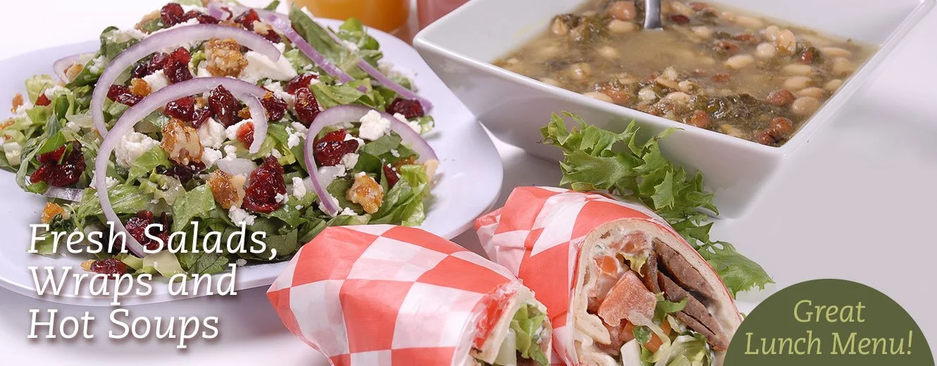 A plate of fresh salad with cranberries, nuts, and cheese, a wrap cut in half showing meat and vegetables, a bowl of hot soup with beans and vegetables, and a small side of lettuce, with an overlay text reading "Fresh Salads, Wraps and Hot Soups" and