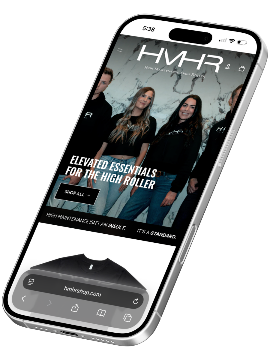 Smartphone displaying a website for HMR, featuring a group of four people wearing black branded shirts, with the headline 'Elevated Essentials for the High Roller' and a shop now button.