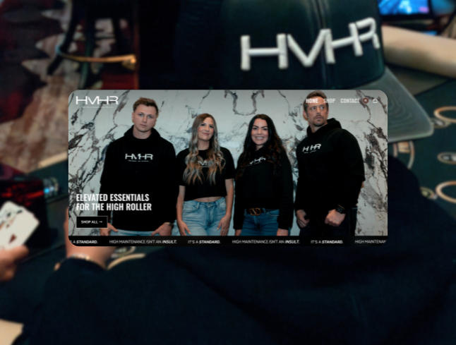 Four people standing in front of a marble wall with HMHR branding, three women and one man, all wearing black clothing with HMHR logo, in what looks like a showroom or store.