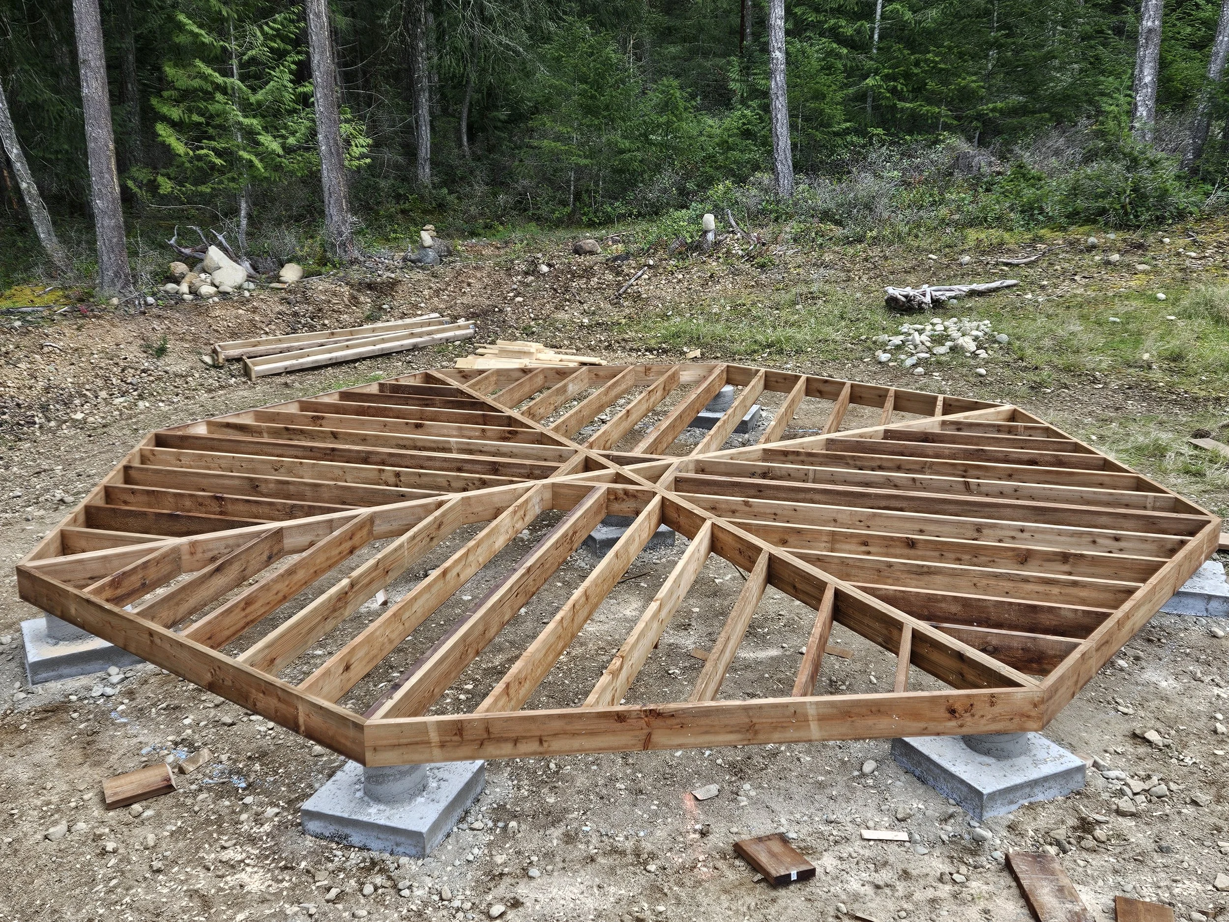 Wooden framework for a small building or deck on concrete blocks in a wooded area