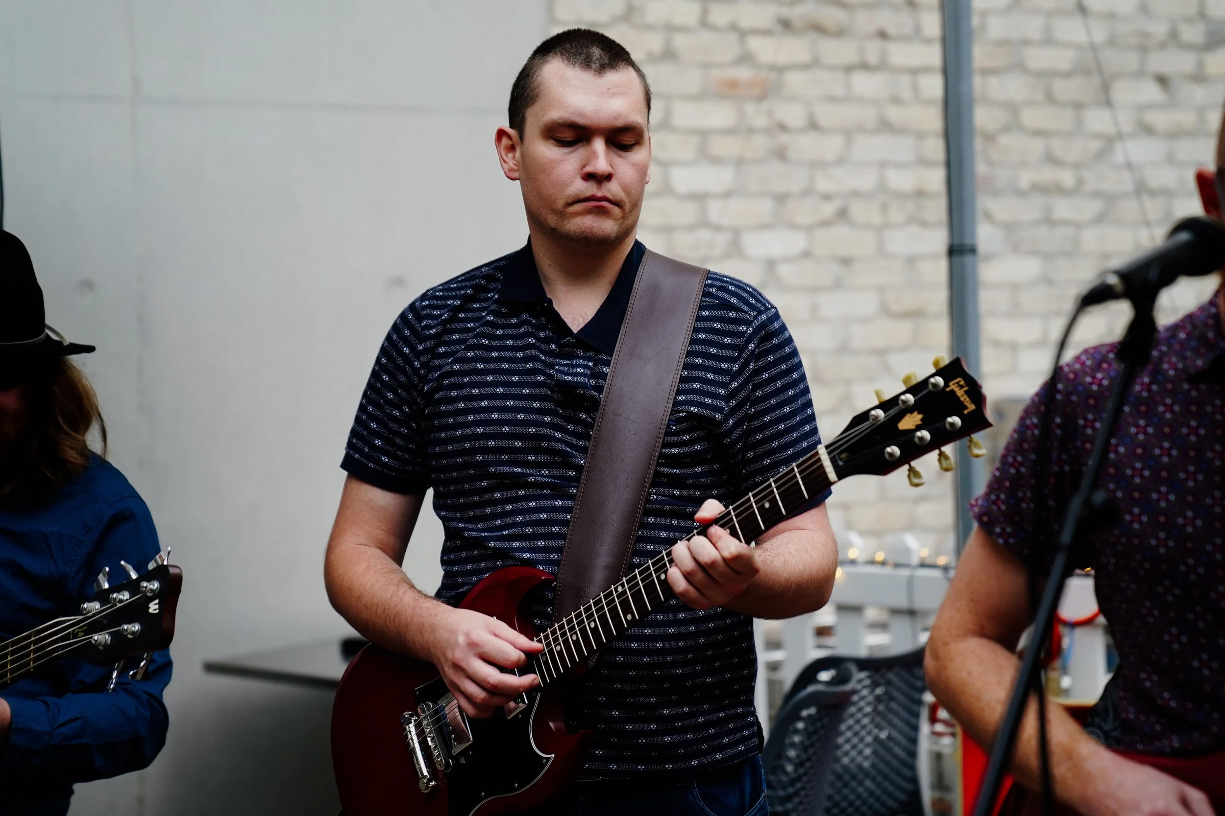 Young man playing an electric guitar at a social gathering.