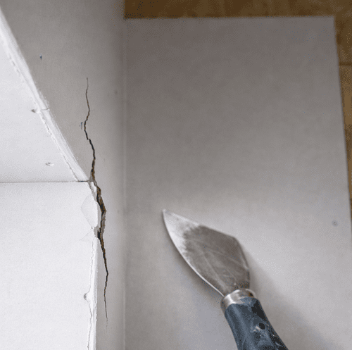 straight drywall seam crack above a painted door frame