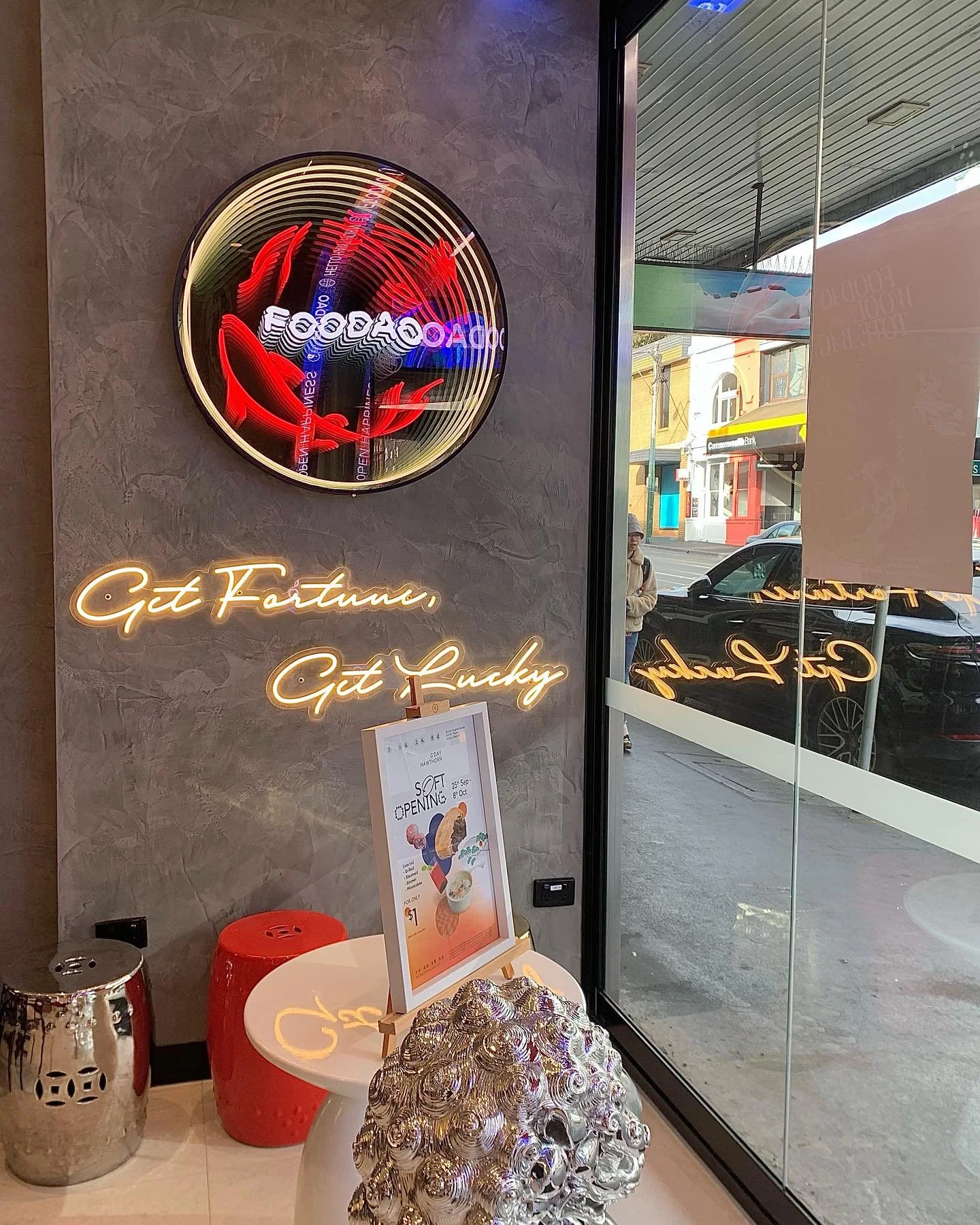 Decorative skull sculpture made of shiny silver shells, displayed inside a store near a glass window.