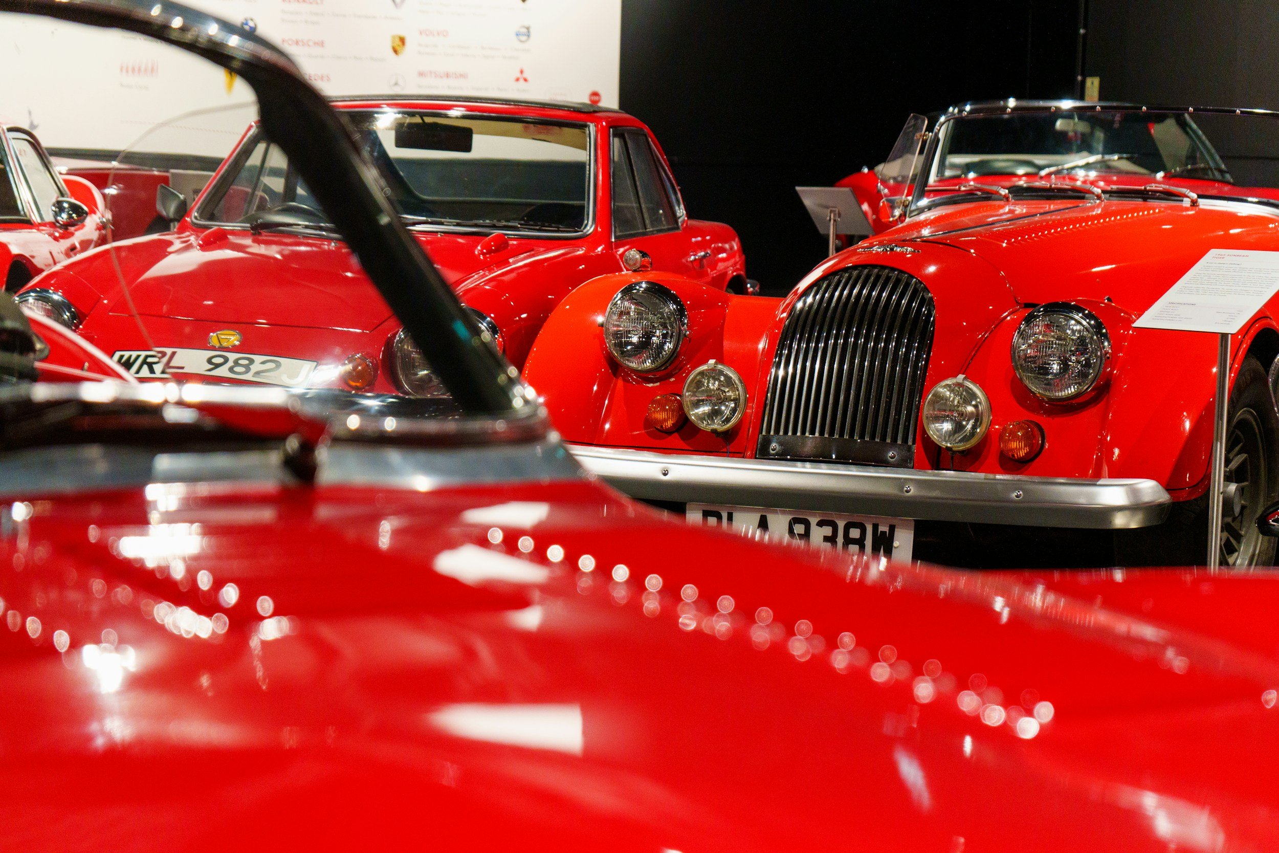 Display of vintage red cars in an automotive exhibit or museum.