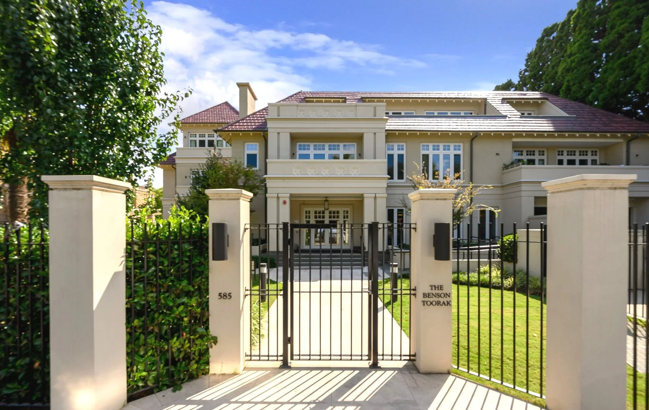 Front view of Toorak luxury retirement apartments surrounded by lush green trees.