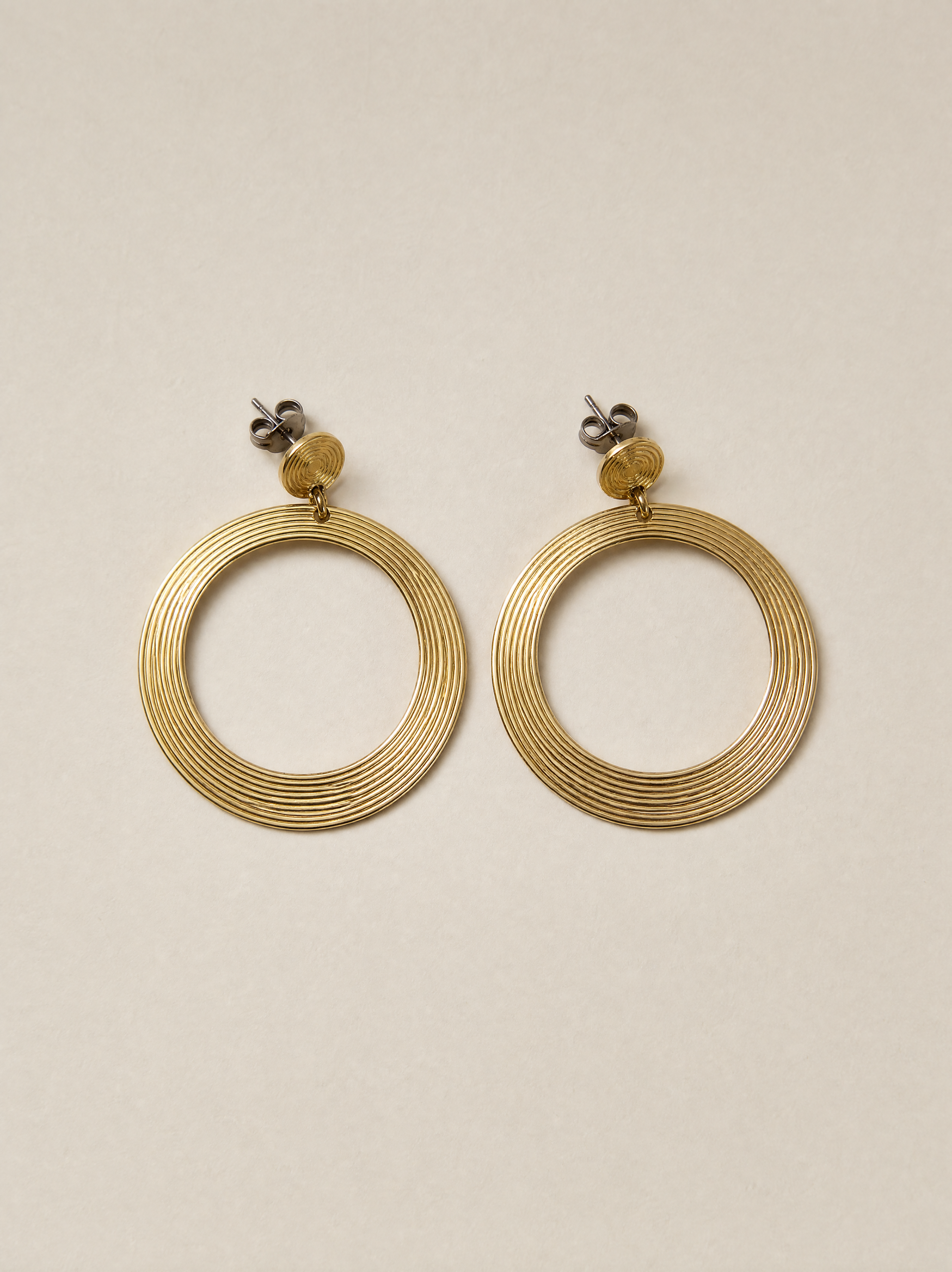 Generated with Kive.ai - Gold hoop earrings make a flat lay of only earrings.png