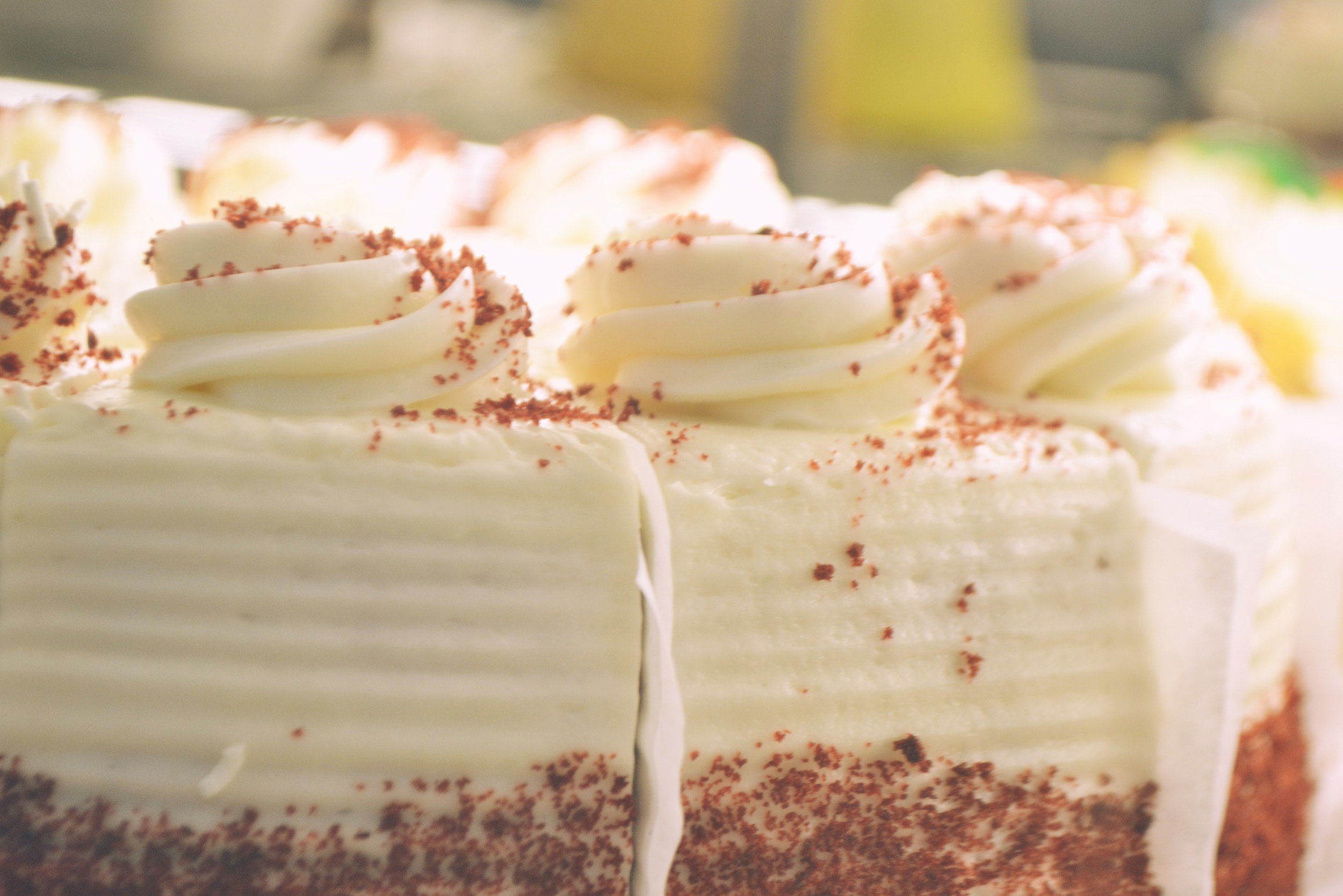 Close-up of a slice of cake decorated with white frosting and sprinkled with red crumbs.