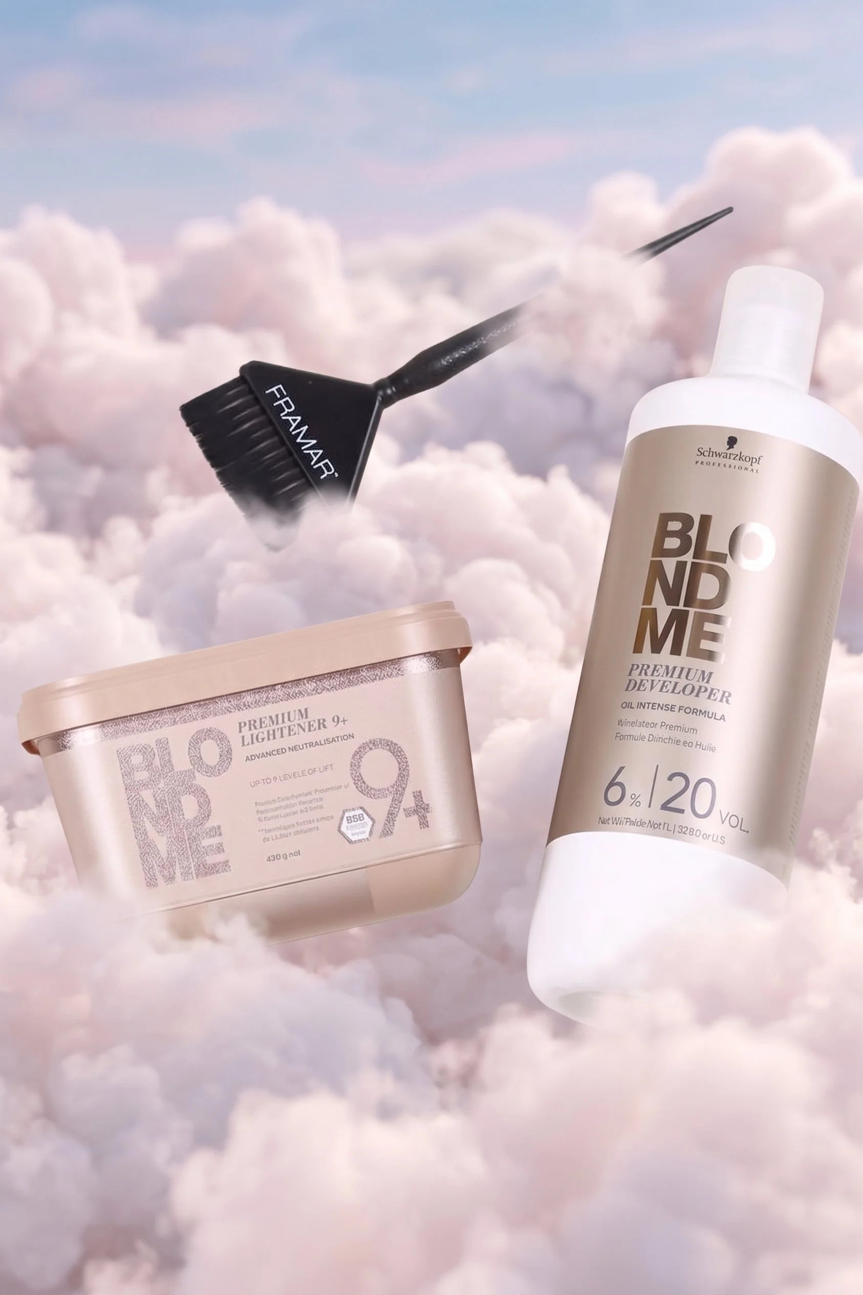 Skincare products floating among pink and white clouds, including a bottle of Schwarzkopf BlondMe developer, a jar of BlondMe lightener, and a black brush with a pointed tip labeled 'FRANMAR'.