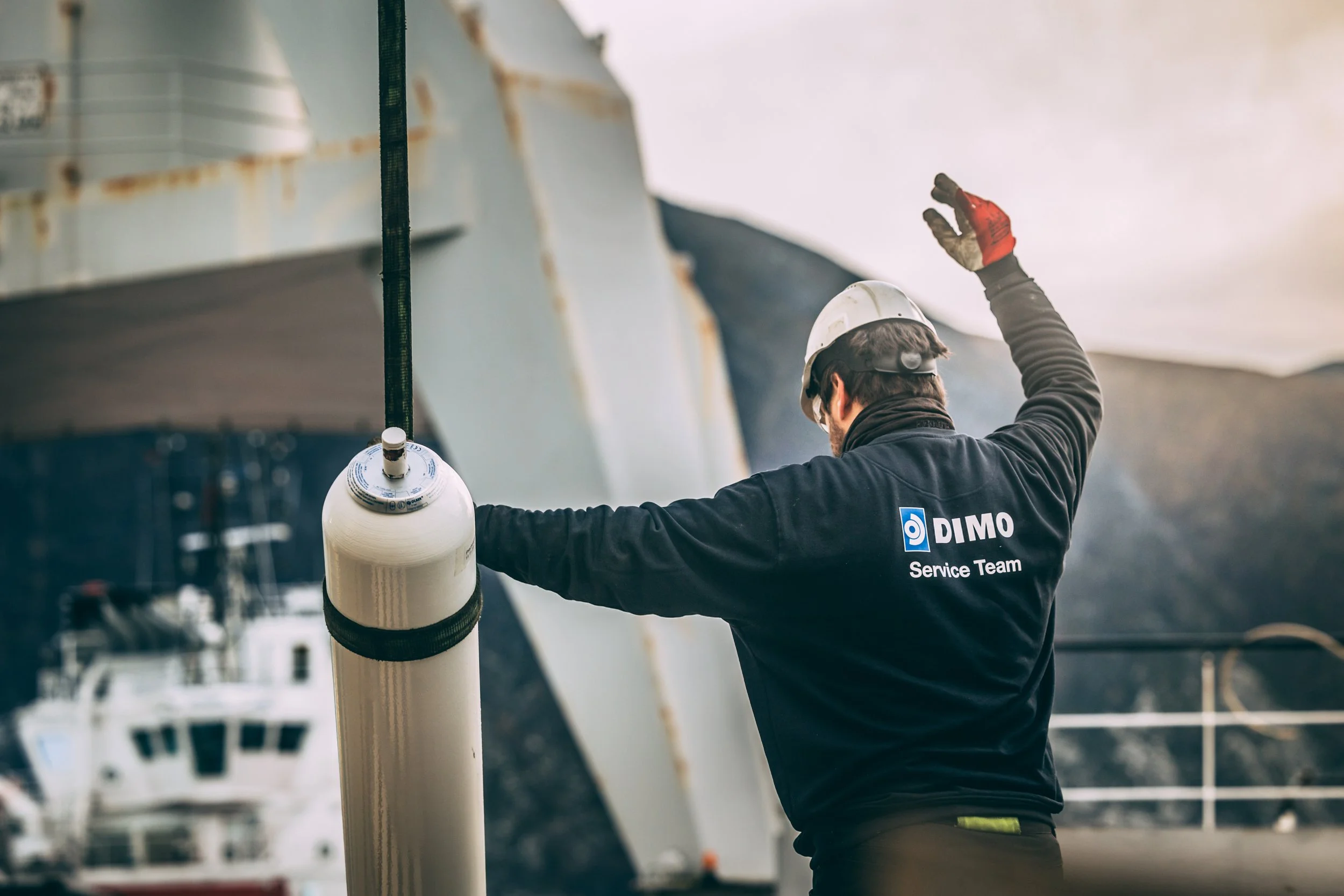 Accumulator, akkumulator, Kleven verft, assembly. Ein Dimo arbeidar iført hjelm og arbeidskle som jobber på et industriområde.