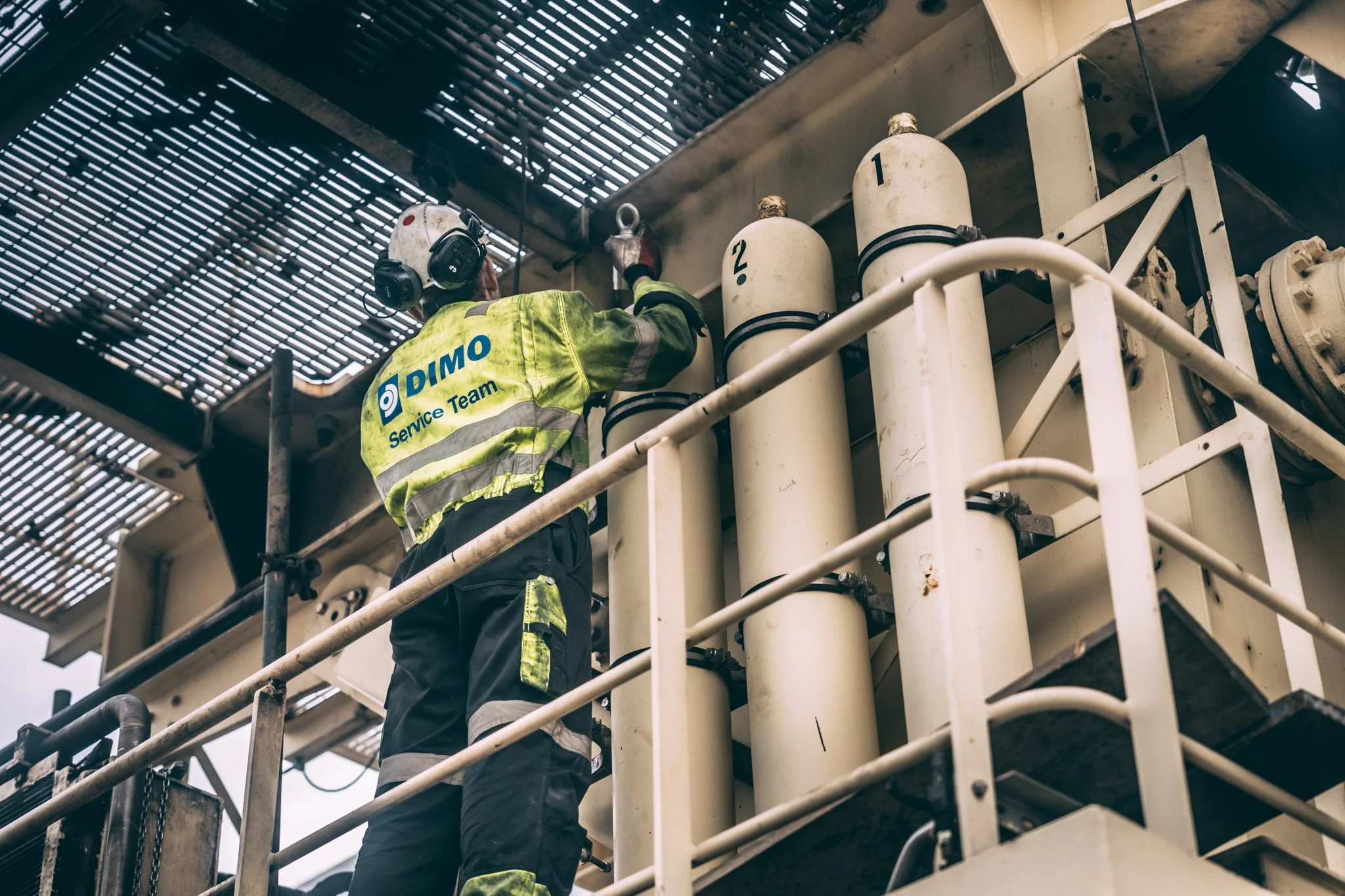 Accumulator, akkumulator, Kleven verft. En arbeider i sikkerhetsutstyr som jobber på en plattform med store, merkelagte tanker.