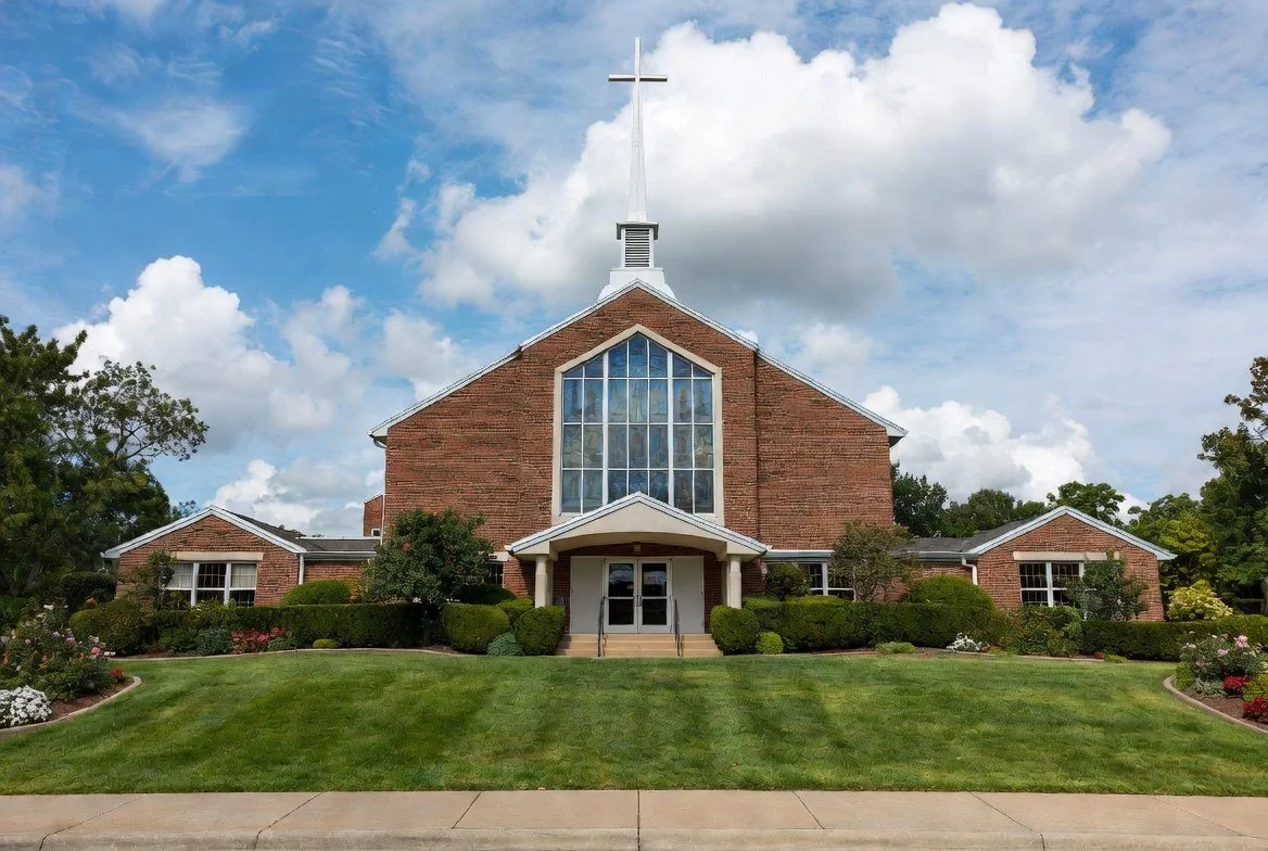 Brick church building with large stained glass window and manicured lawn, section 06: Irrigation & Sprinkler system services.