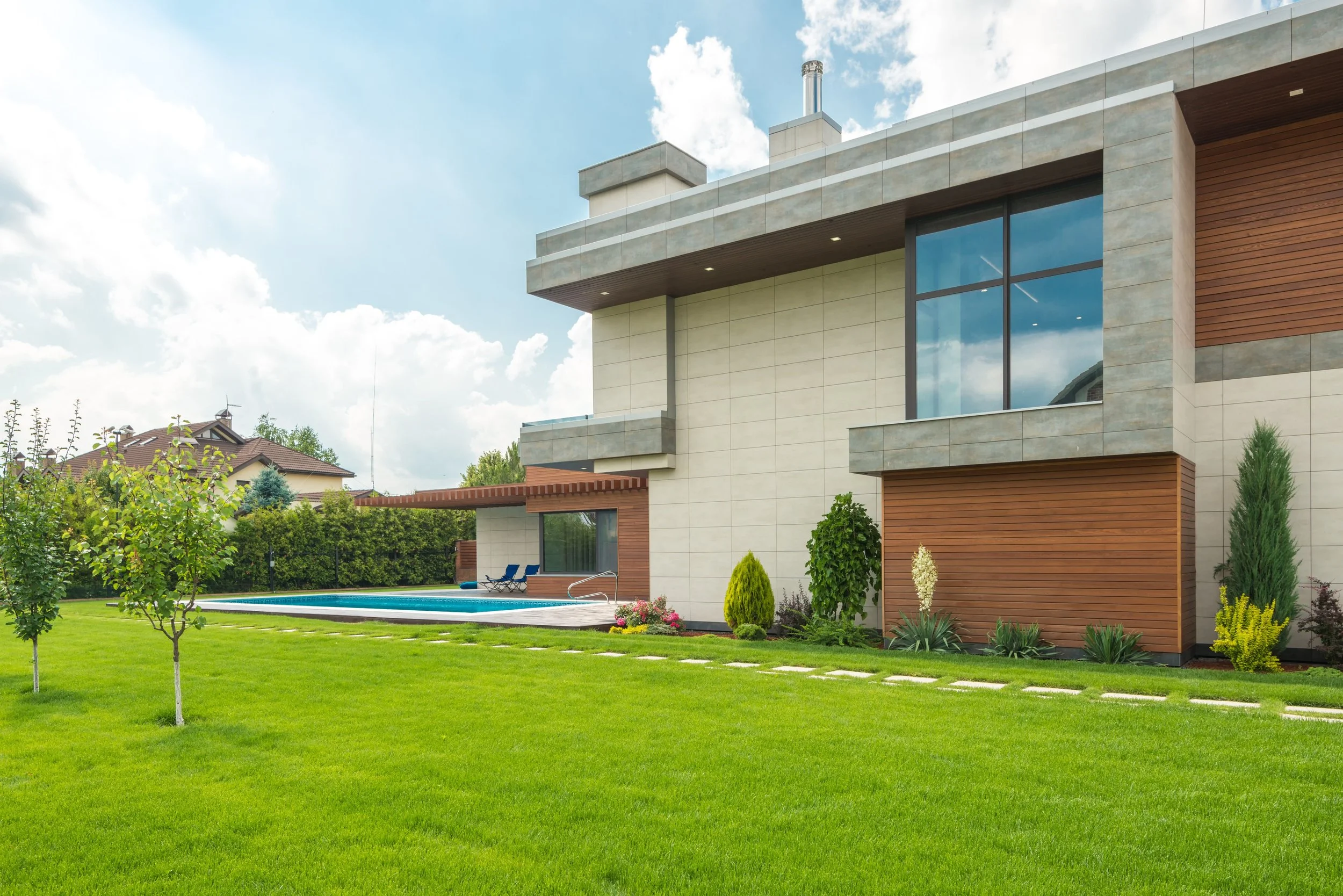 Modern home with swimming pool and lush green lawn