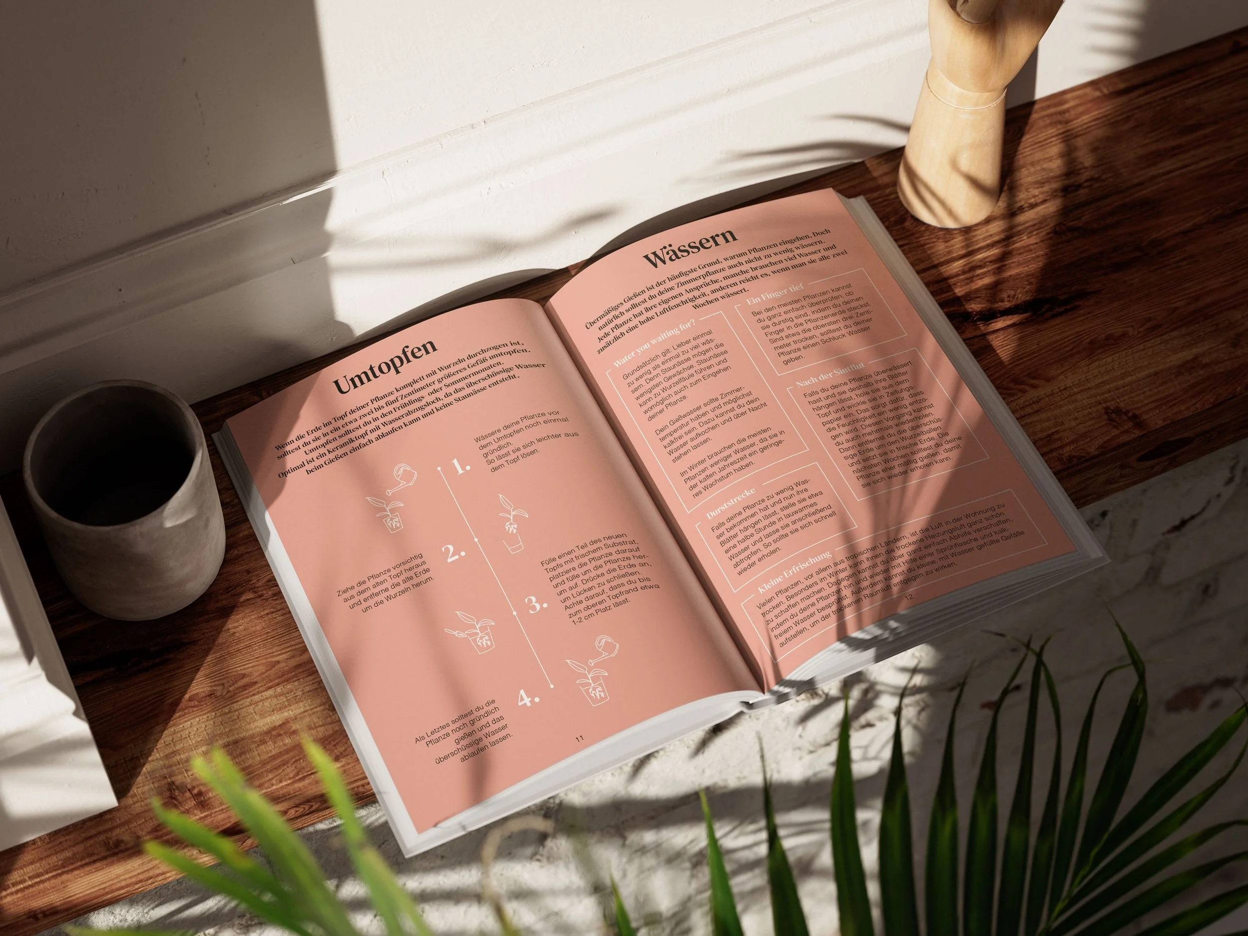 Ein offenen Buch mit einem rosa Seiten, das auf einem Holztisch liegt. Neben dem Buch steht eine weiße Vase. Es scheint Sonnenlicht auf das Buch zu fallen.