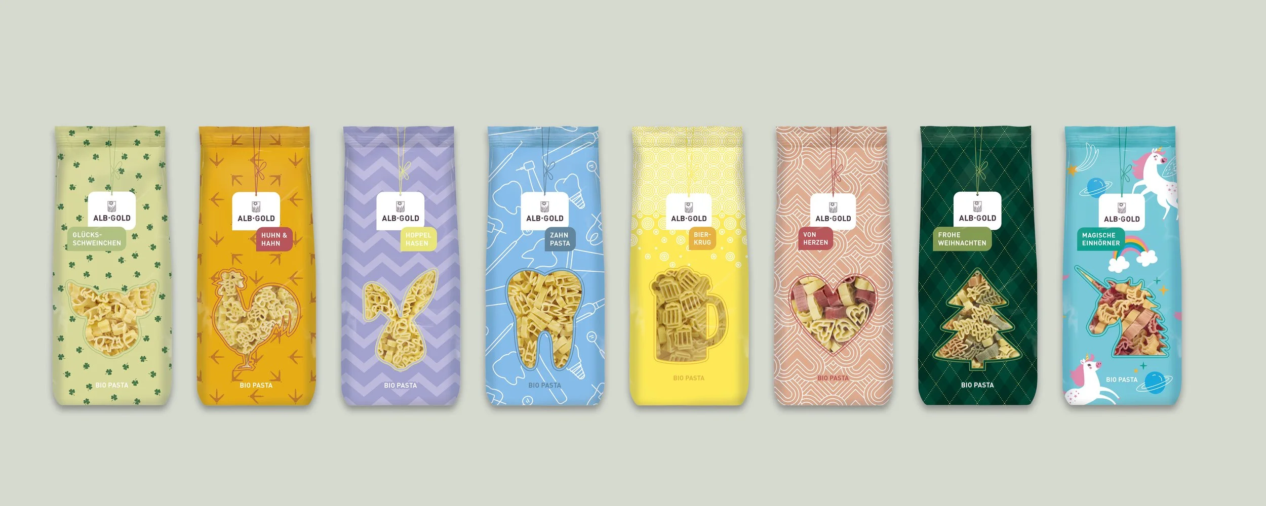 Verschiedene bunte Packungen Bio-Pasta in Tier- und Fantasiewesen-Designs, darunter Schwein, Hahn, Hase, Zahn-, Bier- und Herz-Figur, Weihnachtsbaum und Einhorn.