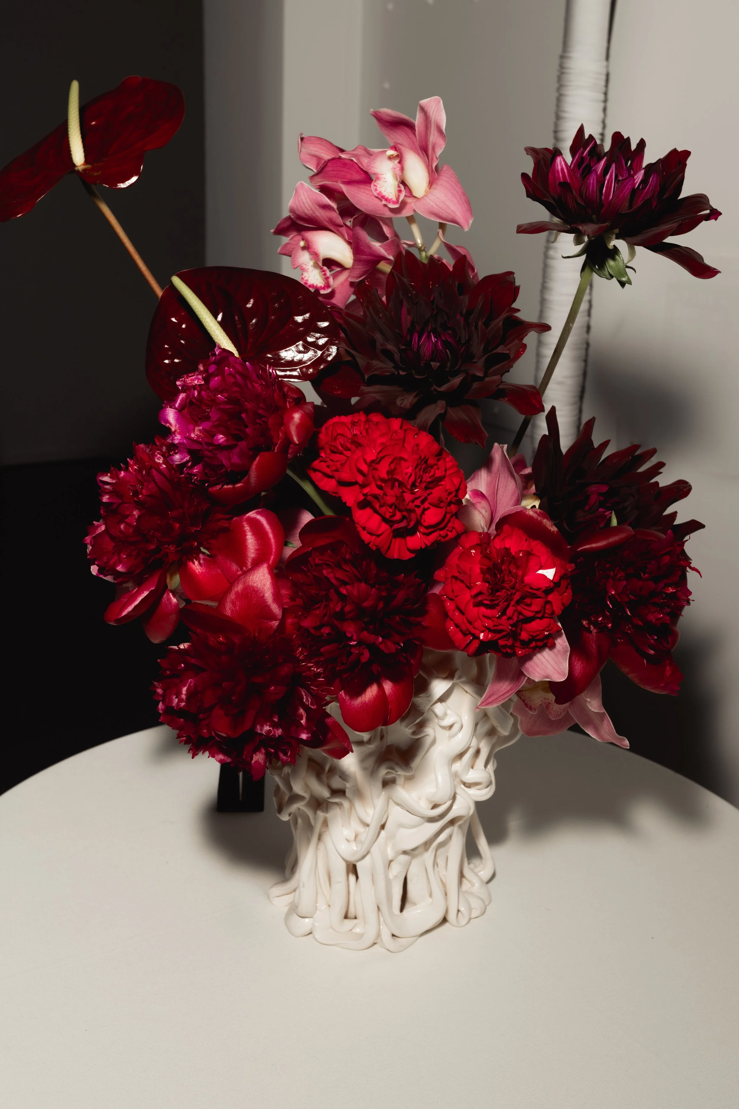 Vase arrangement in deep burgundy and pink tones
