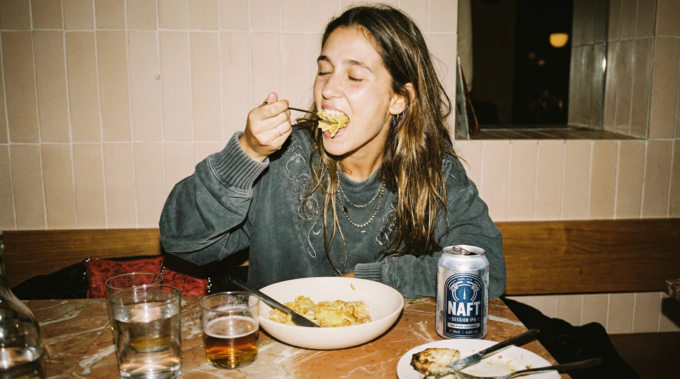 Vrouw eet pasta in restaurant met drankje en naft biertje. Mensen drinken een naft bier. Ipa naft.