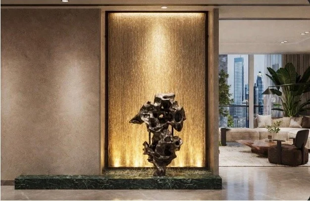 Modern interior with a bronze sculpture on a dark green marble base, gold textured wall background, and city skyline through large window.