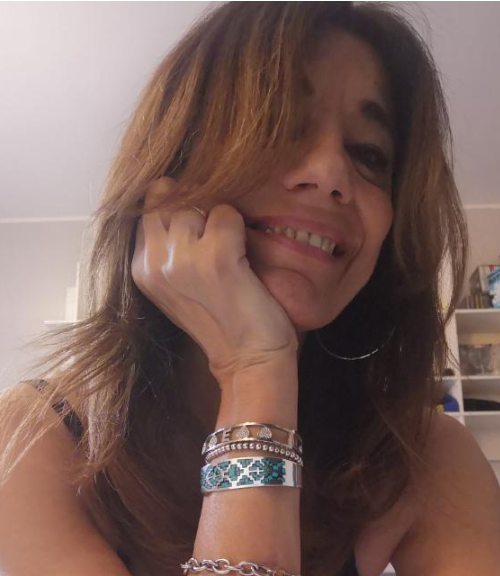 Donna sorridente con braccialetti, in un ambiente interno.