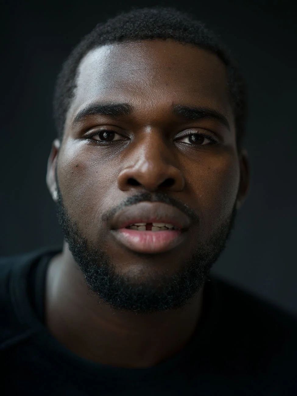 Professional headshot on dark background by Chris Mann London