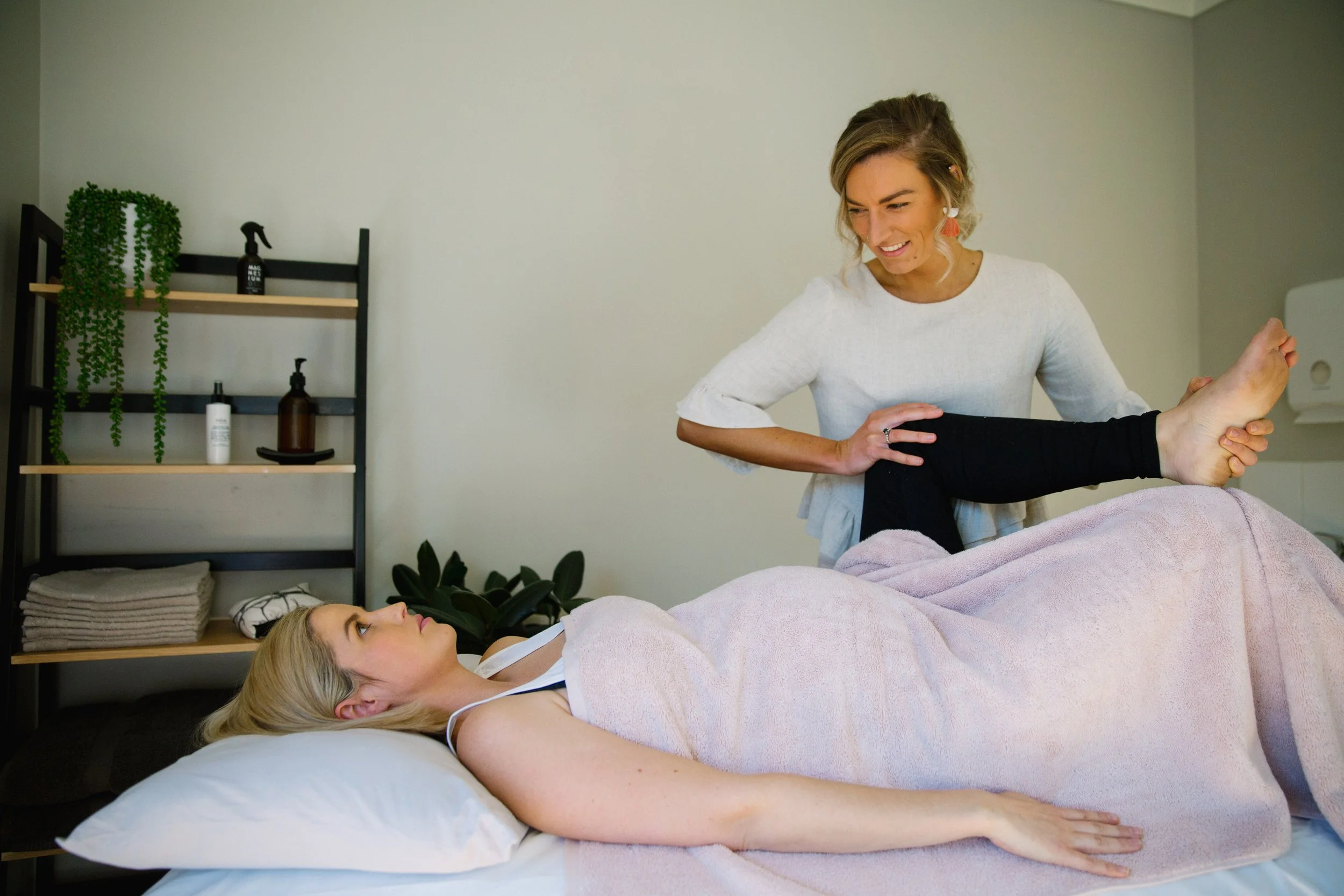 Osteopath assessing a patient’s hip and leg during treatment