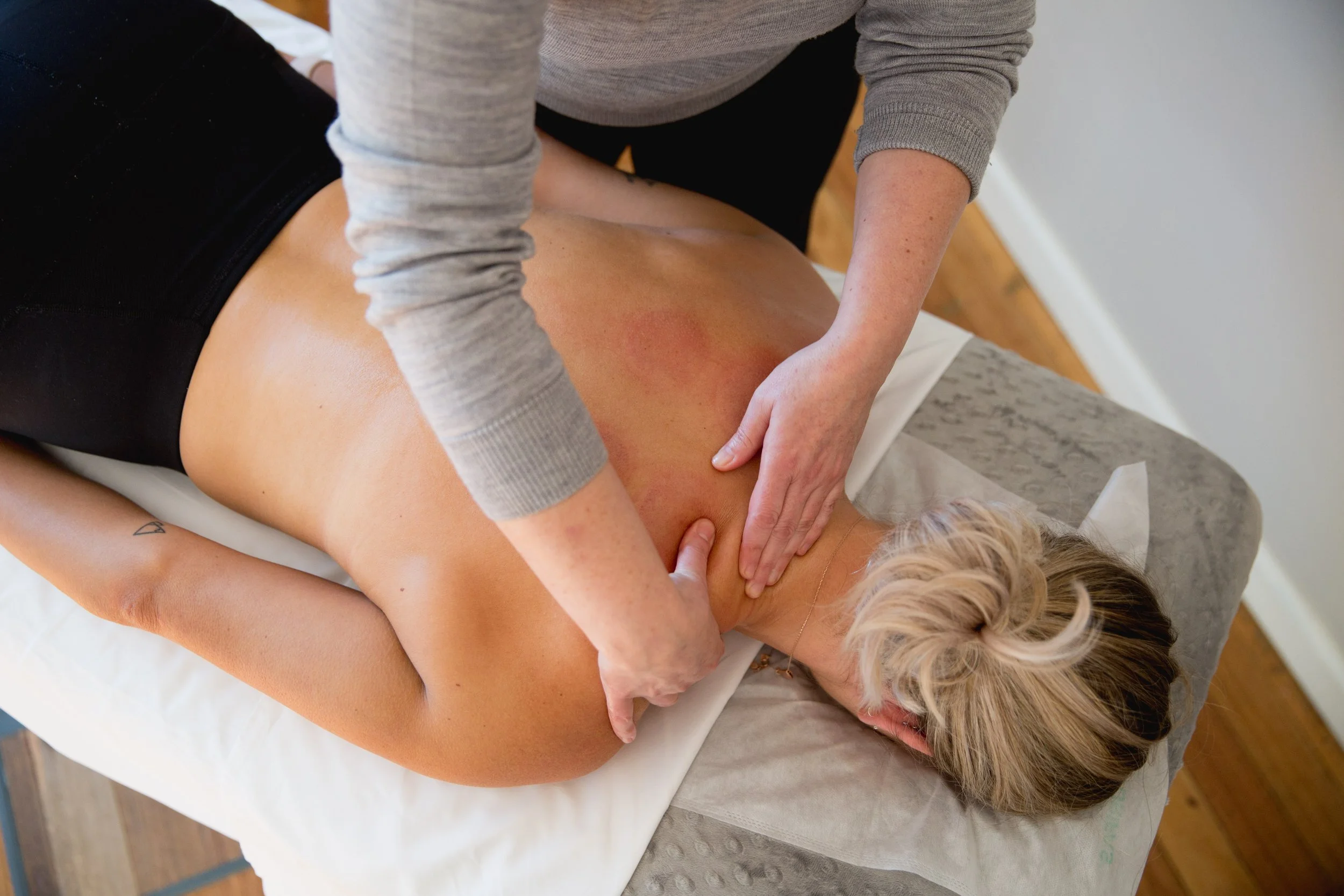 Myotherapist providing hands-on soft tissue treatment to the back