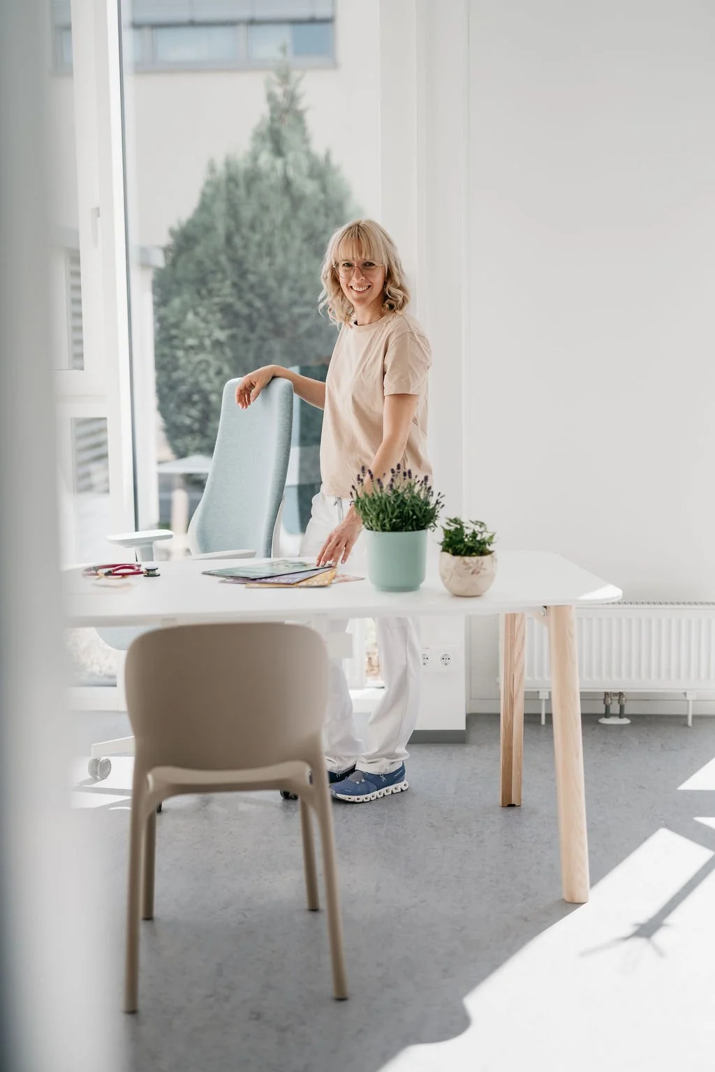 Dr. Judith Hirzenberger, Wahlärztin mit Schwerpunkt Phytotherapie in Linz, steht mit verschränkten Armen vor heller Wand.
