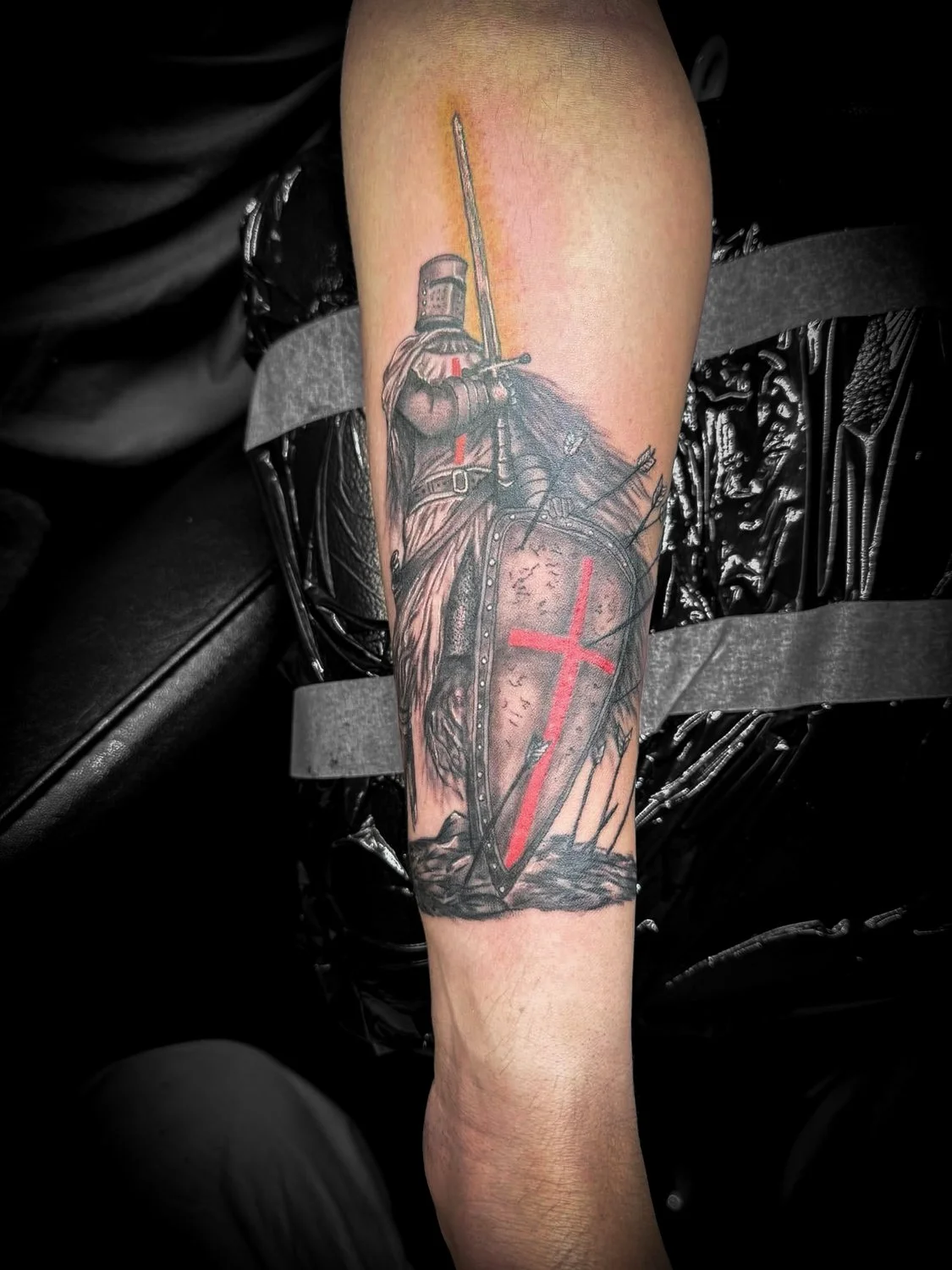 Tattoo of a medieval knight with a sword and shield.