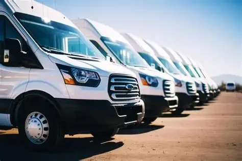 Row of white commercial vans parked in a lot