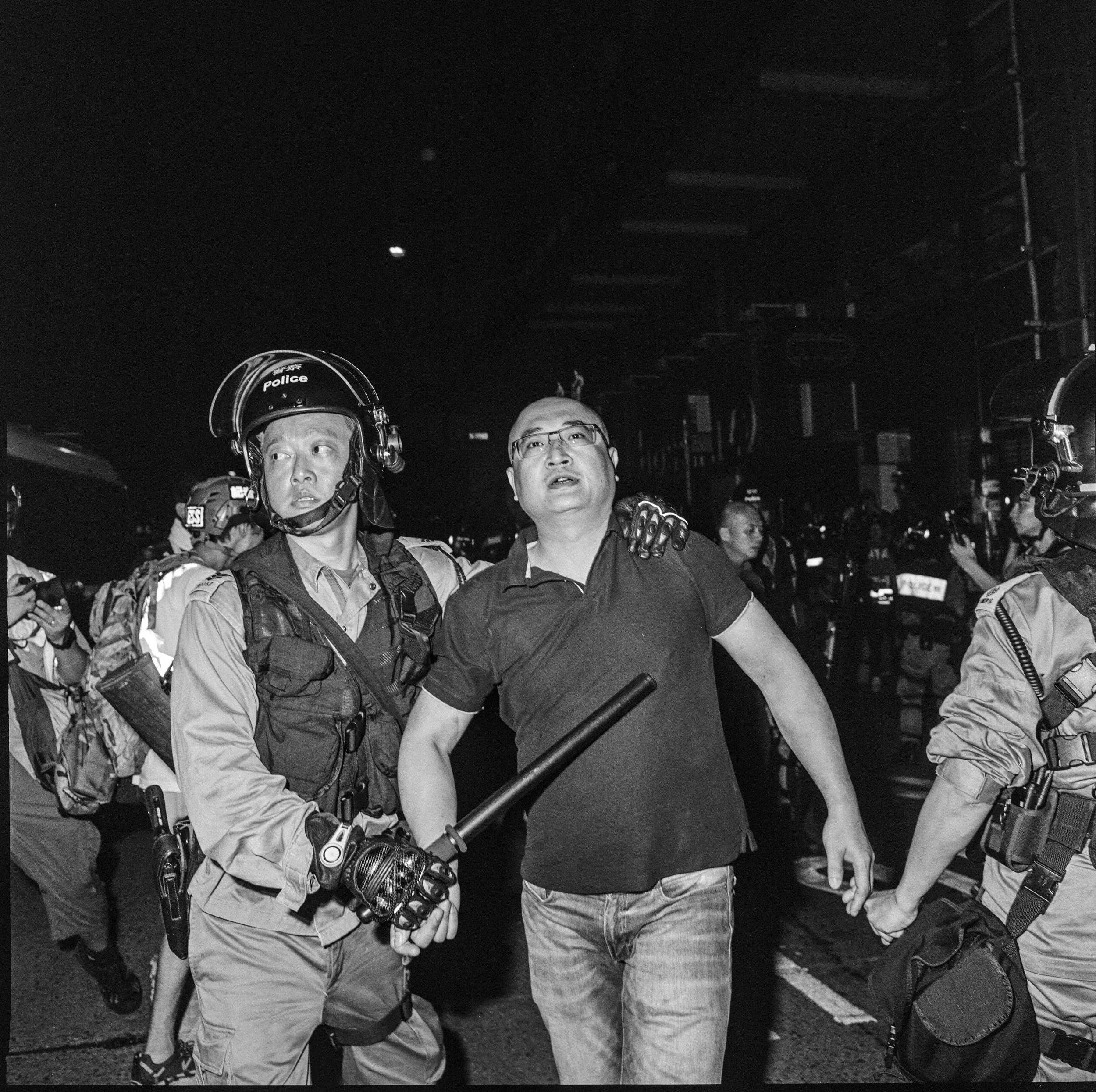 A pro China supporter (R) is escorted away after allegedly assaulting members of the press, during clashes with anti government protestors in the Fortress Hill area in Hong Kong, September 2019. Hong Kong has been battered by anti government protests