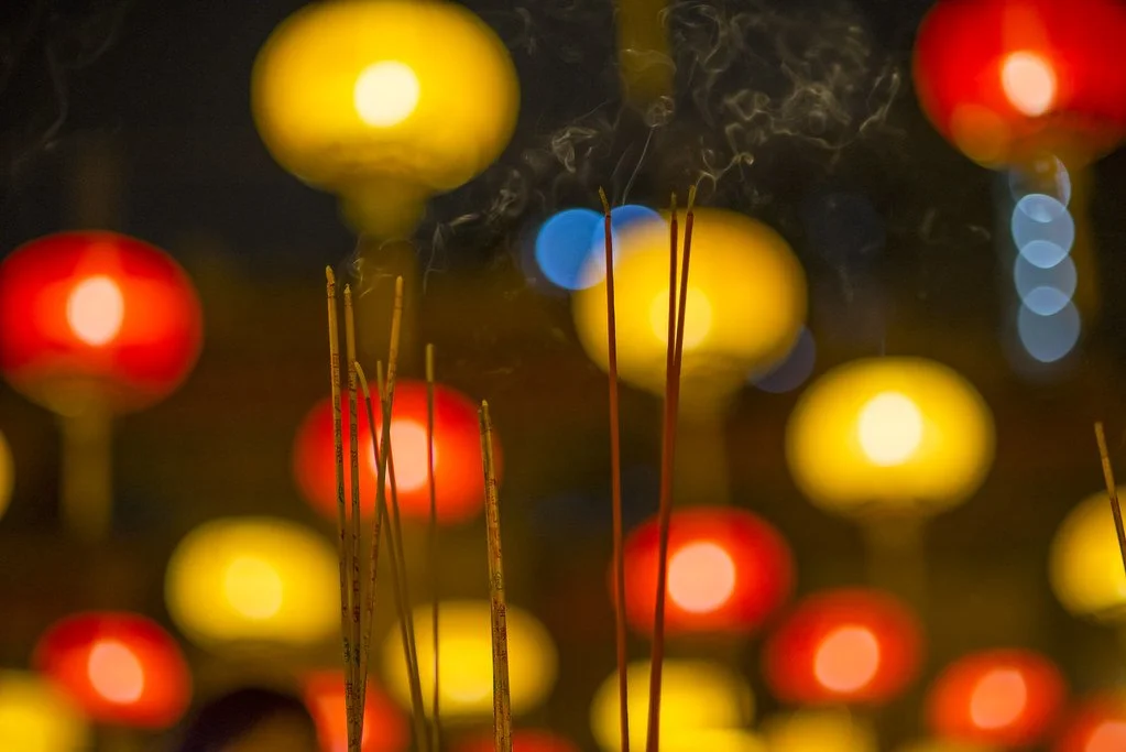 Joss stick burn in front of lanterns on the eve of Chinese New Year in Hong Kong