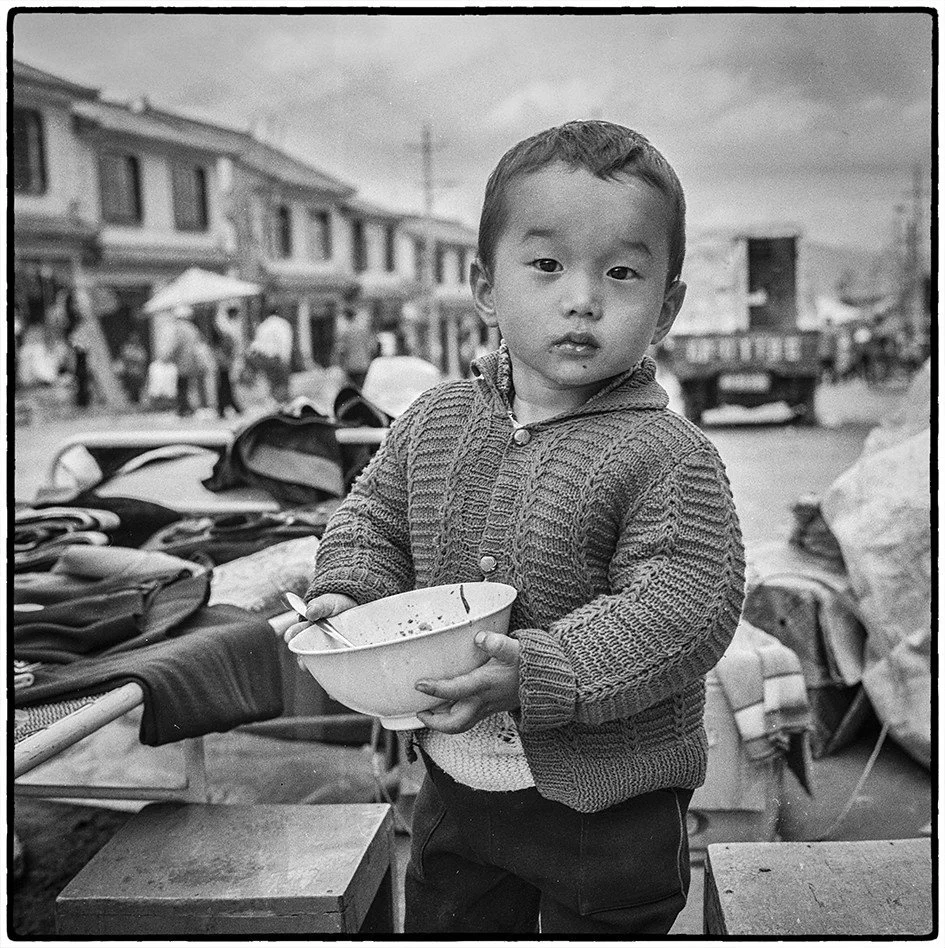Market boy with a bowl of noodles, Dali, 1996.