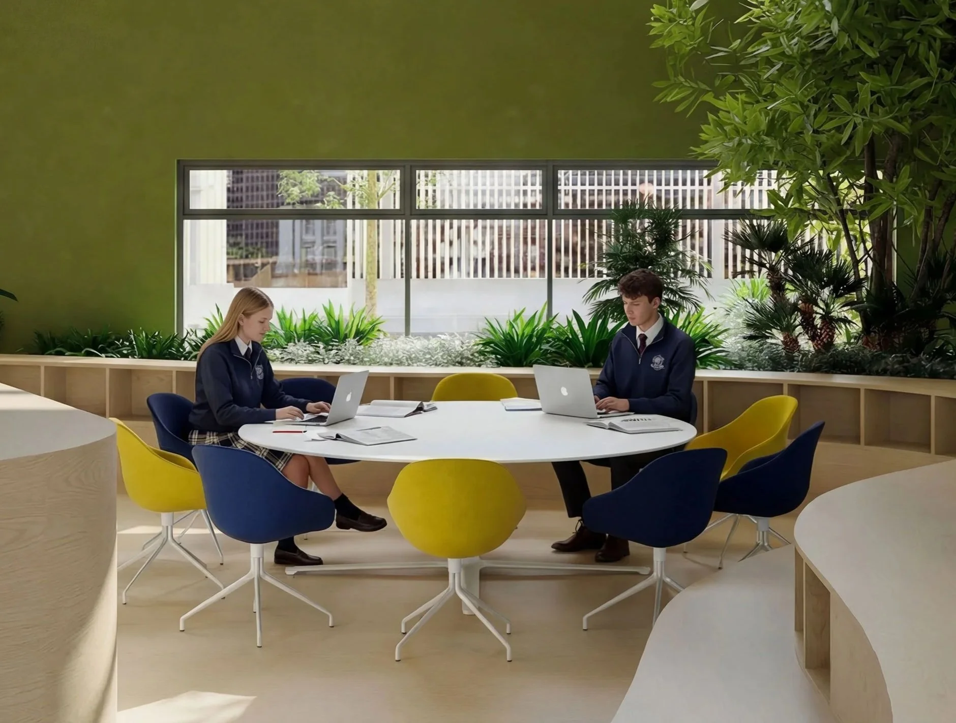 Two students in school uniforms sitting at a round table in a bright, modern room with large windows, green plants, and colorful chairs, working on laptops.