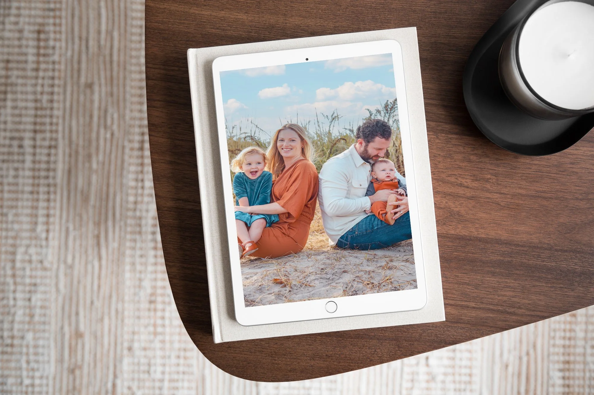 Tablet showing a photo of a woman and a young boy at the beach, with the woman giving a kiss on the cheek to the boy, and a small brown dog in front of them.