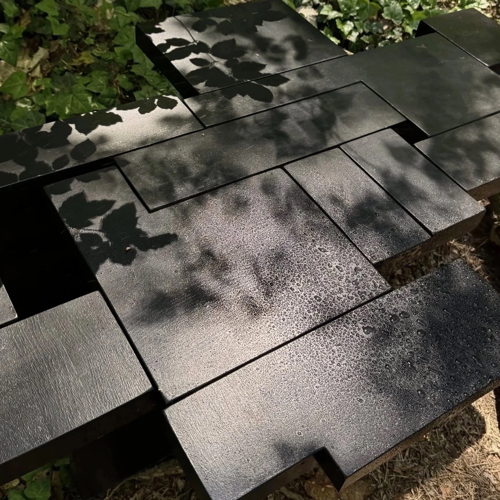 Handcrafted sculptural solid oak coffee table by KHARAD STUDIO photographed outdoors in a forest setting.