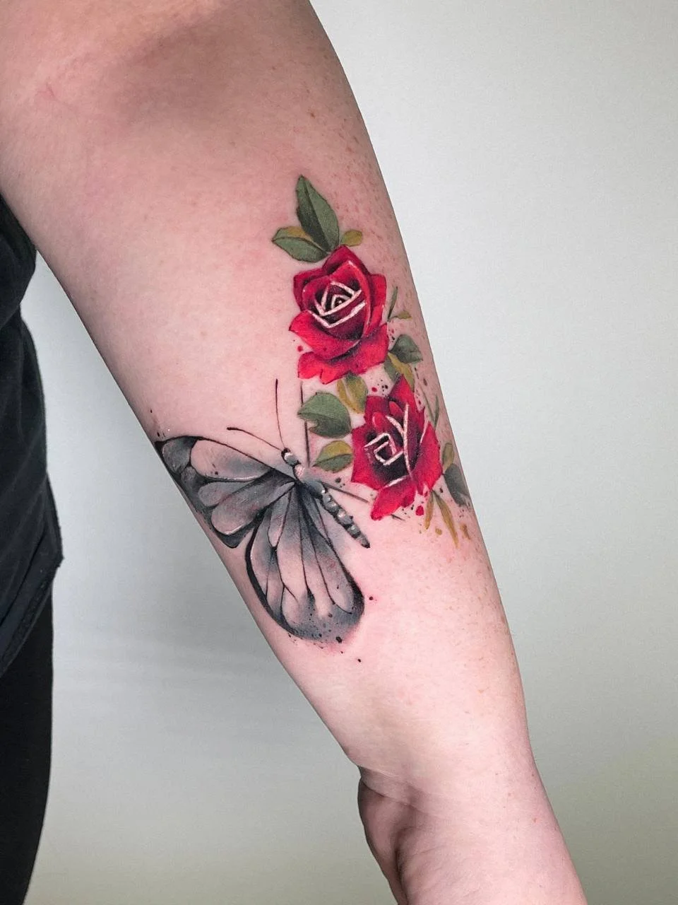Kleines Aquarell-Tattoo mit Schmetterling und roten Rosen